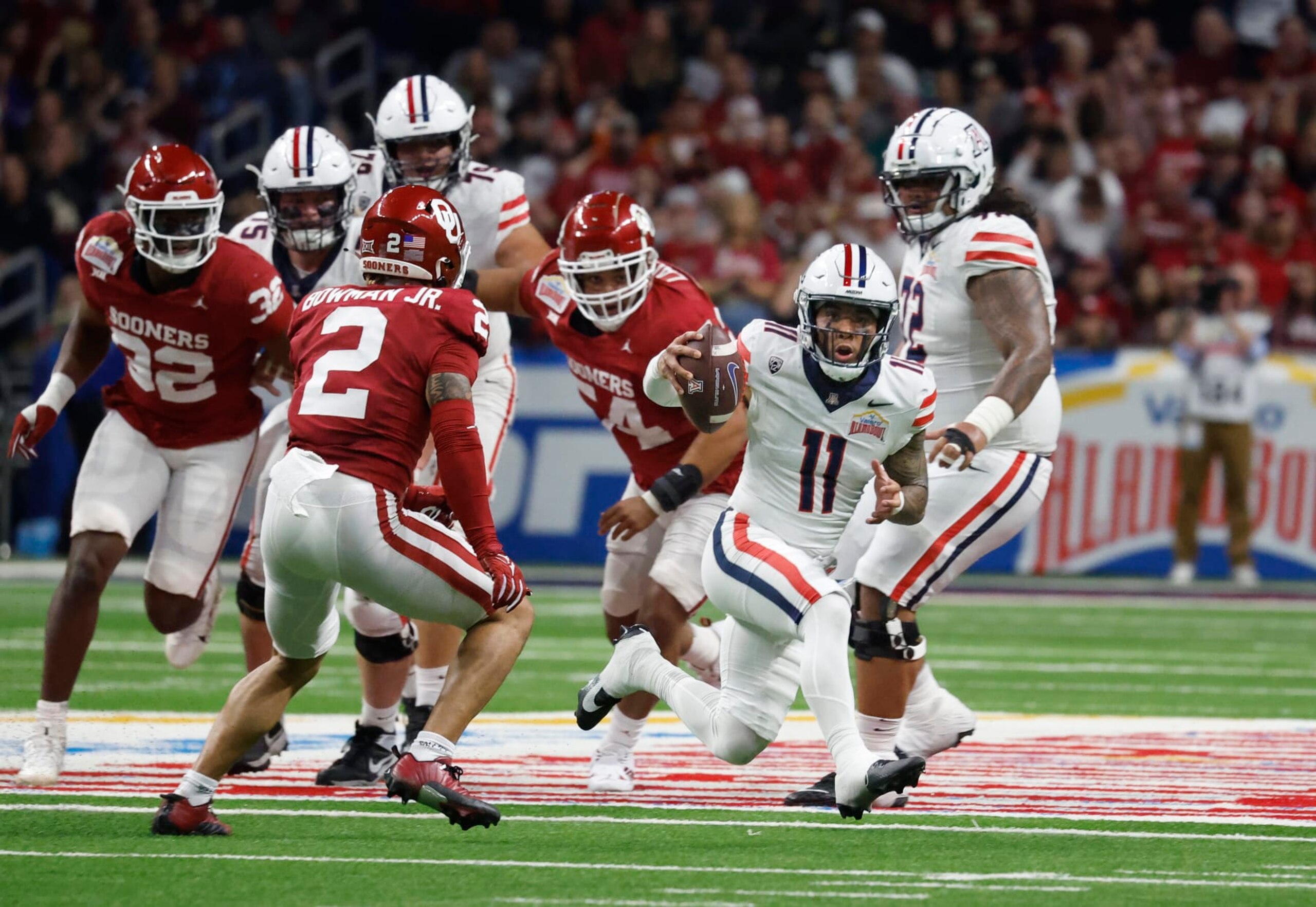 SAN ANTONIO, TX - DECEMBER 28:  Noah Fifita #11 of the Arizona Wildcats scrambles against the Oklahoma Sooners in the first half at the Valero Alamo Bowl at the Alamodome on December  28, 2023 in San Antonio, Texas.  (Photo by Ronald Cortes/Getty Images)