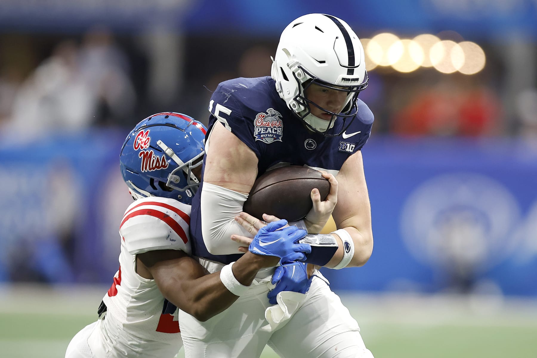ATLANTA, GEORGIA - DECEMBER 30: Drew Allar #15 of the Penn State Nittany Lions is tackled by Jared Ivey #15 of the Mississippi Rebels during the fourth quarter in the Chick-fil-A Peach Bowl at Mercedes-Benz Stadium on December 30, 2023 in Atlanta, Georgia. (Photo by Alex Slitz/Getty Images)