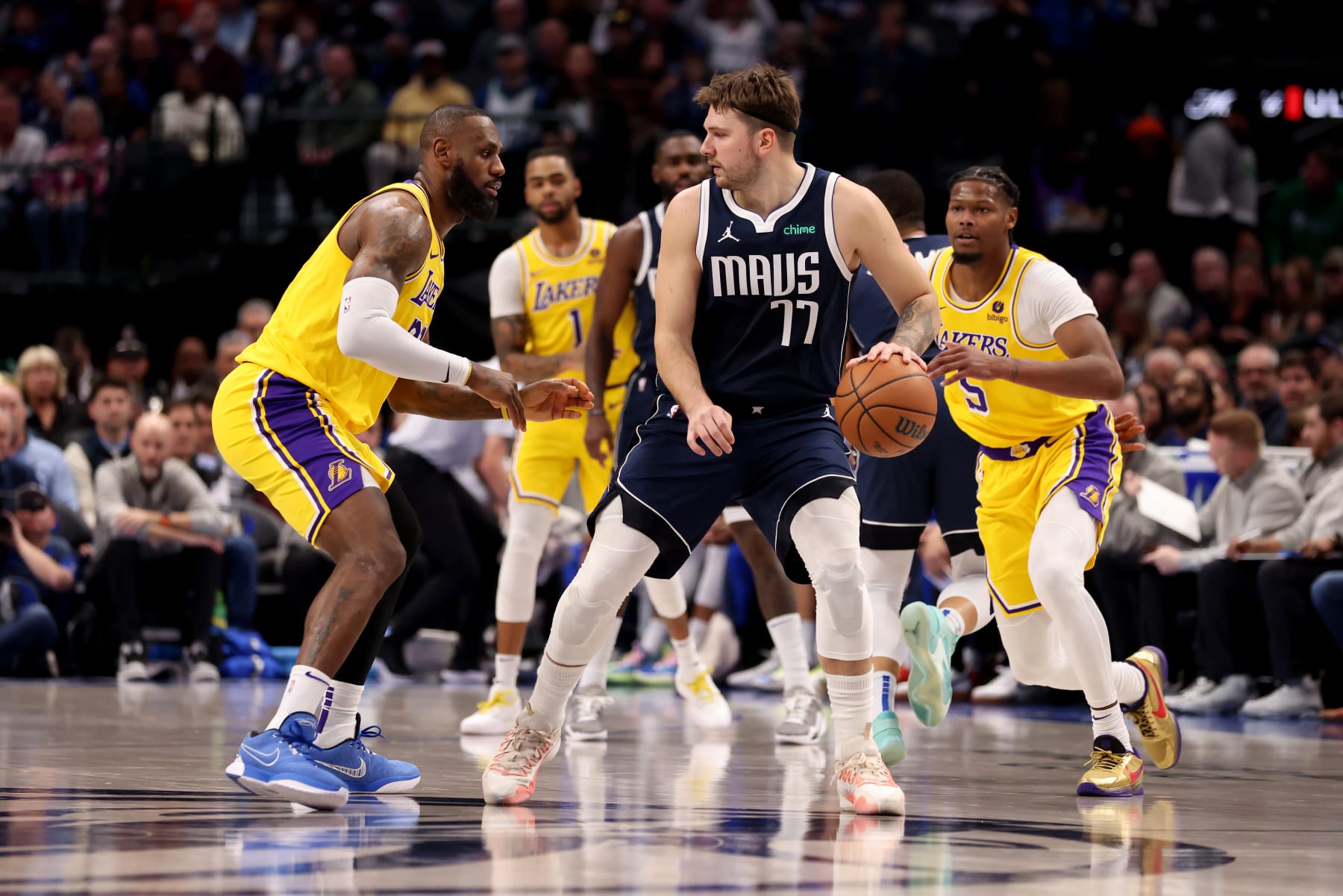 DALLAS, TEXAS - DECEMBER 12: Luka Doncic #77 of the Dallas Mavericks dribbles the ball while guarded by LeBron James #23 of the Los Angeles Lakers in the first half at American Airlines Center on December 12, 2023 in Dallas, Texas.  NOTE TO USER: User expressly acknowledges and agrees that, by downloading and or using this photograph, User is consenting to the terms and conditions of the Getty Images License Agreement. (Photo by Tim Heitman/Getty Images)