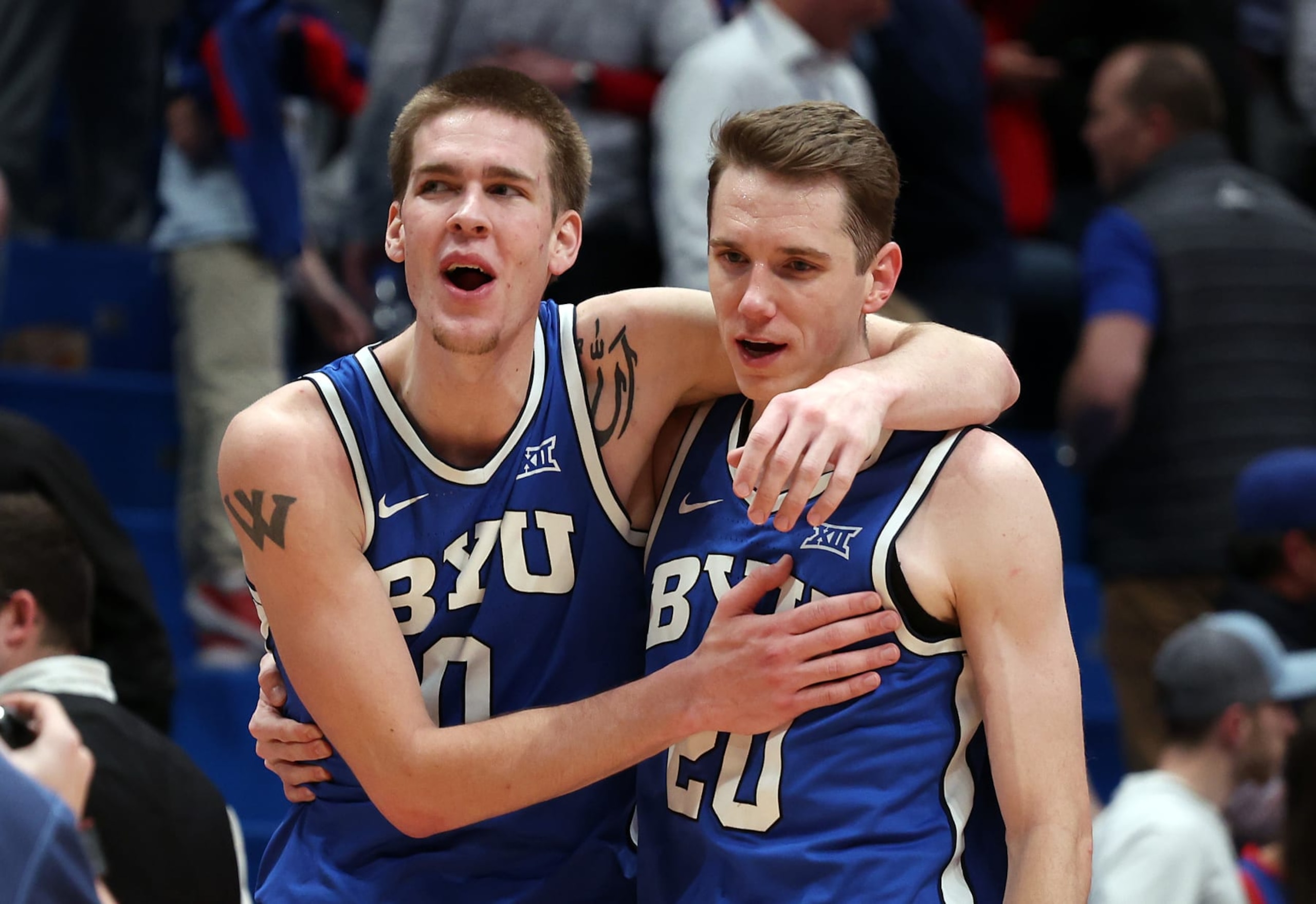 LAWRENCE, KANSAS - FEBRUARY 27:  Noah Waterman #0 and Spencer Johnson #20 of the Brigham Young Cougars celebrate after BYU defeated the Kansas Jayhawks 76-68 to win the game at Allen Fieldhouse on February 27, 2024 in Lawrence, Kansas. (Photo by Jamie Squire/Getty Images)