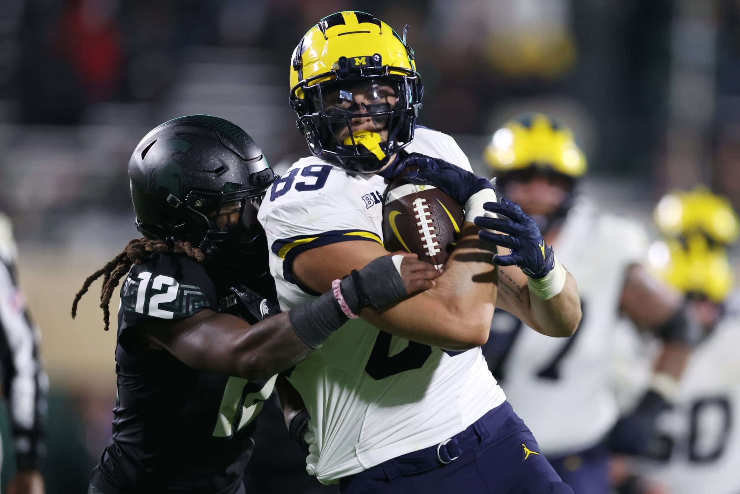 EAST LANSING, MICHIGAN - OCTOBER 21: AJ Barner #89 of the Michigan Wolverines battles for yards after a first half catch against Chester Kimbrough #12 of the Michigan State Spartans at Spartan Stadium on October 21, 2023 in East Lansing, Michigan. (Photo by Gregory Shamus/Getty Images) EAST LANSING, MICHIGAN - OCTOBER 21: AJ Barner #89 of the Michigan Wolverines battles for yards after a first half catch against Chester Kimbrough #12 of the Michigan State Spartans at Spartan Stadium on October 21, 2023 in East Lansing, Michigan. (Photo by Gregory Shamus/Getty Images)
