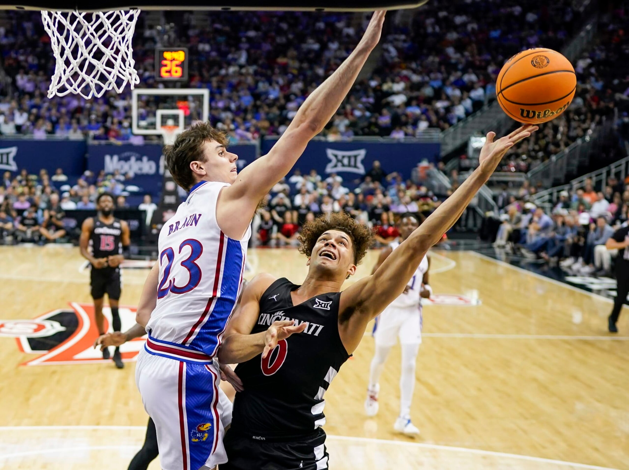 KANSAS CITY, MISSOURI - MARCH 13: Dan Skillings Jr. #0 of the Cincinnati Bearcats shoots against Parker Braun #23 of the Kansas Jayhawks during the first half in the second round of the Big 12 Men's Basketball Tournament at T-Mobile Center on March 13, 2024 in Kansas City, Missouri. (Photo by Jay Biggerstaff/Getty Images) KANSAS CITY, MISSOURI - MARCH 13: Dan Skillings Jr. #0 of the Cincinnati Bearcats shoots against Parker Braun #23 of the Kansas Jayhawks during the first half in the second round of the Big 12 Men's Basketball Tournament at T-Mobile Center on March 13, 2024 in Kansas City, Missouri. (Photo by Jay Biggerstaff/Getty Images)