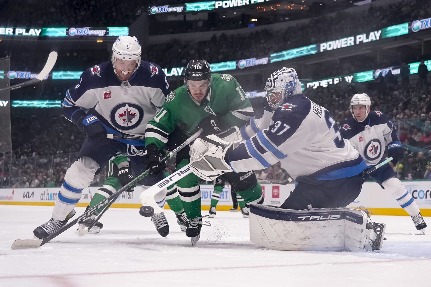 DALLAS, TEXAS - FEBRUARY 29: Logan Stankoven #11 of the Dallas Stars compete for the puck against Brenden Dillon #5 and Connor Hellebuyck #37 of the Winnipeg Jets during the third period at American Airlines Center on February 29, 2024 in Dallas, Texas. (Photo by Sam Hodde/Getty Images)
