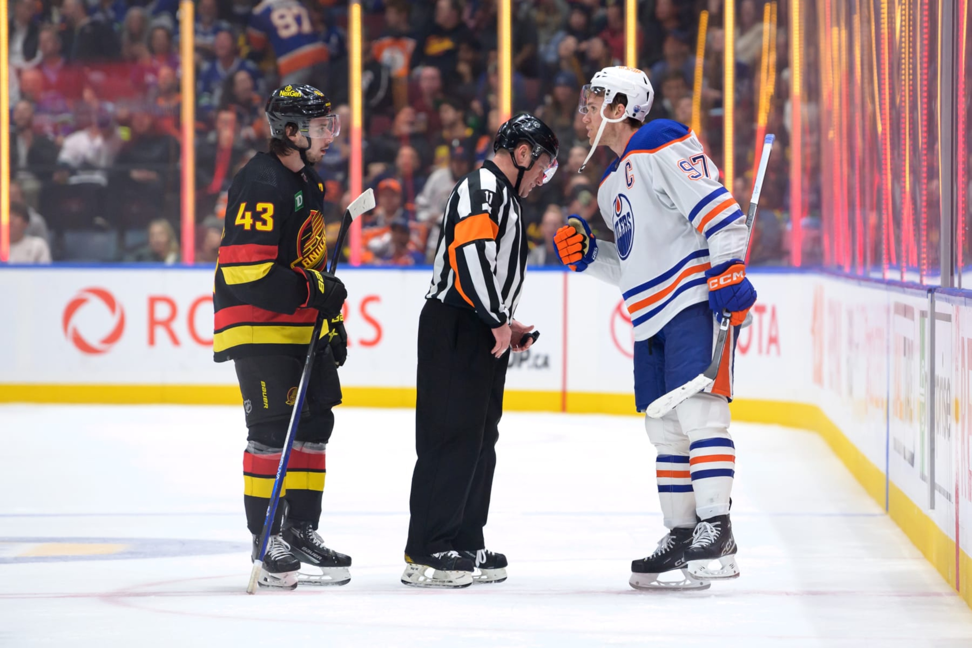 VANCOUVER, CANADA - NOVEMBER 6: Quinn Hughes #43 of the Vancouver Canucks and Connor McDavid #97 of the Edmonton Oilers talk with Referee Kelly Sutherland #11 of their NHL game at Rogers Arena on November 6, 2023 in Vancouver, British Columbia, Canada. (Photo by Derek Cain/Getty Images)