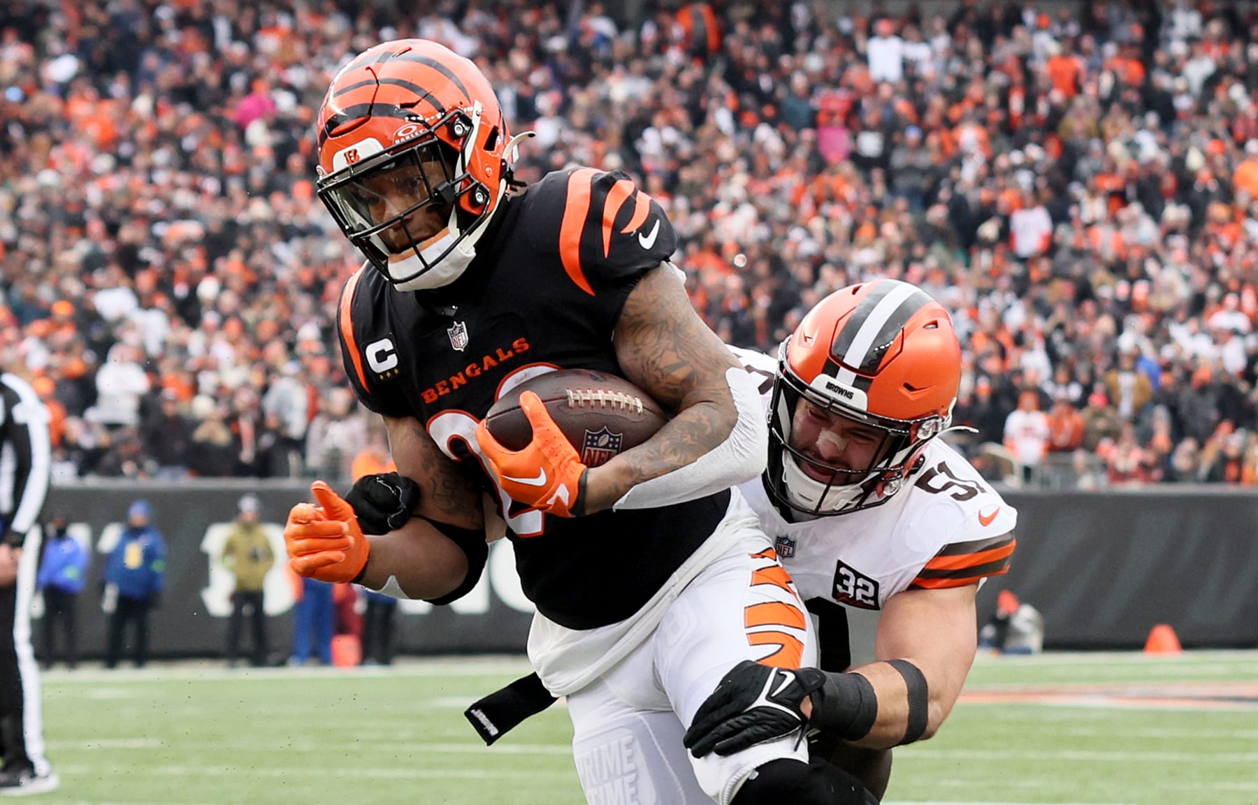 CINCINNATI, OHIO - JANUARY 07: Joe Mixon #28 of the Cincinnati Bengals runs for a touchdown while defended by Jordan Kunaszyk #51 of the Cleveland Browns at Paycor Stadium on January 07, 2024 in Cincinnati, Ohio. (Photo by Andy Lyons/Getty Images)