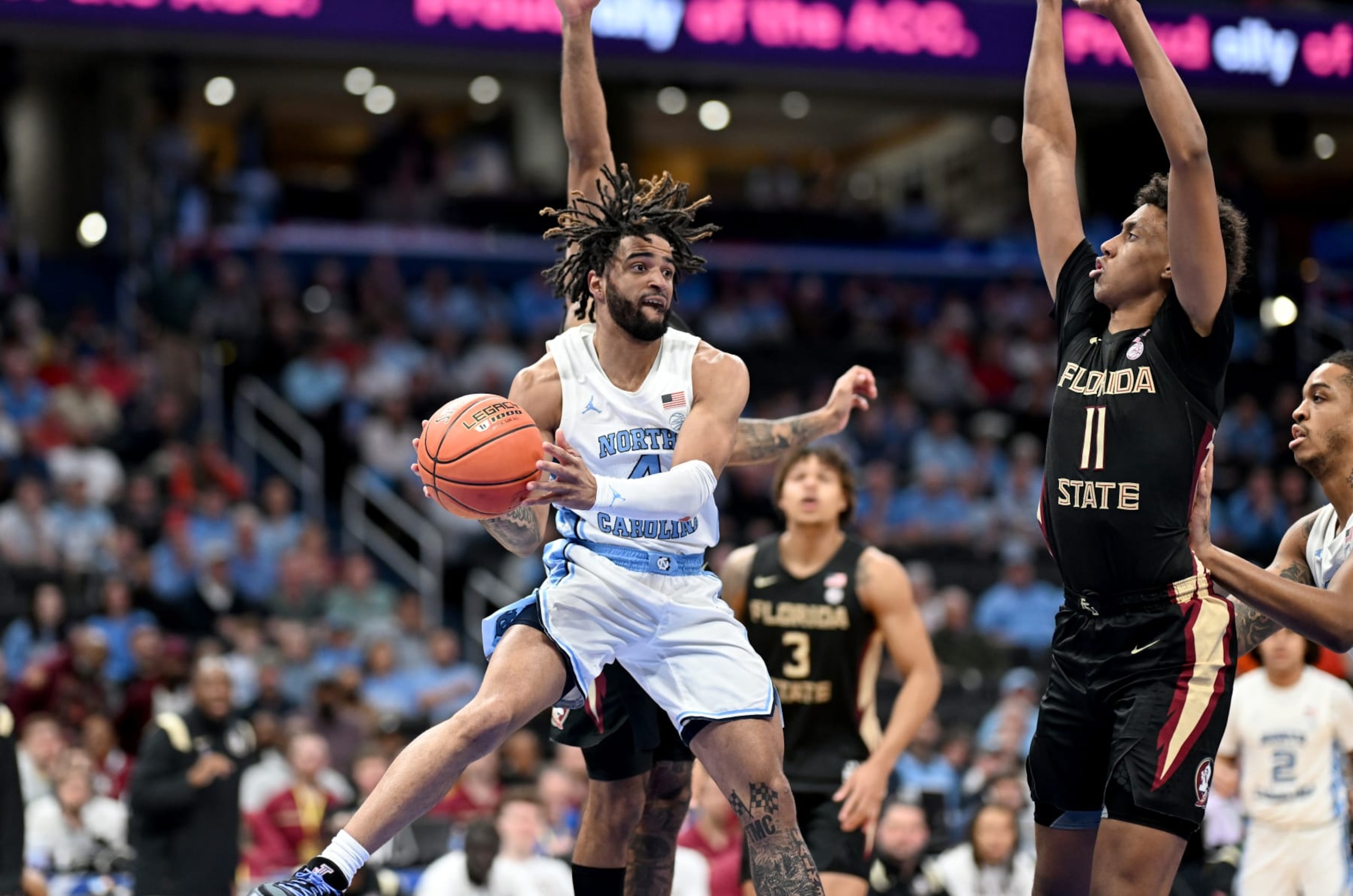 WASHINGTON, DC - MARCH 14: RJ Davis #4 of the North Carolina Tar Heels passes the ball in the first half against Baba Miller #11 of the Florida State Seminoles in the Quarterfinals of the ACC Men's Basketball Tournament  at Capital One Arena on March 14, 2024 in Washington, DC. (Photo by Greg Fiume/Getty Images)