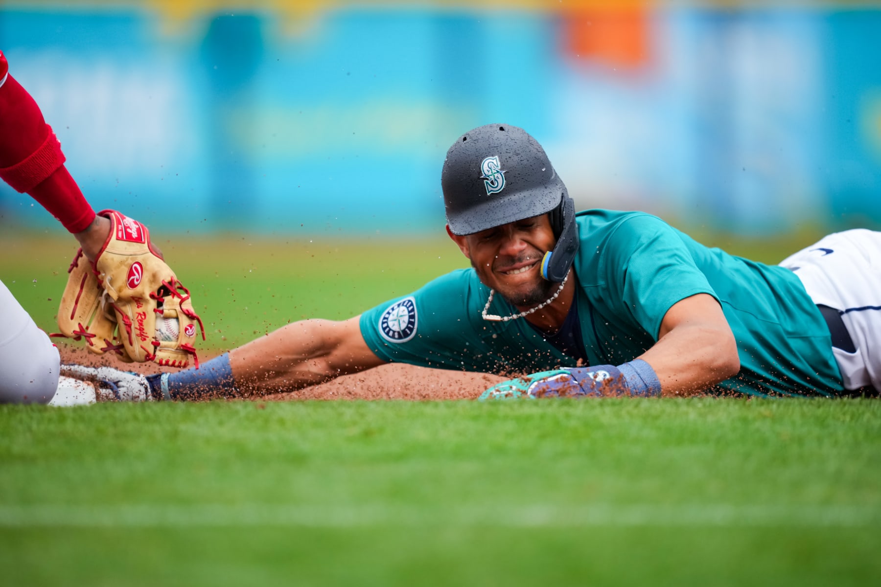 PEORIA, ARIZONA - MARCH 07: Julio Rodriguez #44 of the Seattle Mariners dives back into third base safely ahead of the tag from Luis Rengifo #2 of the Los Angeles Angels in the first inning during a spring training game at Peoria Sports Complex on March 07, 2024 in Peoria, Arizona. (Photo by Aaron Doster/Getty Images)