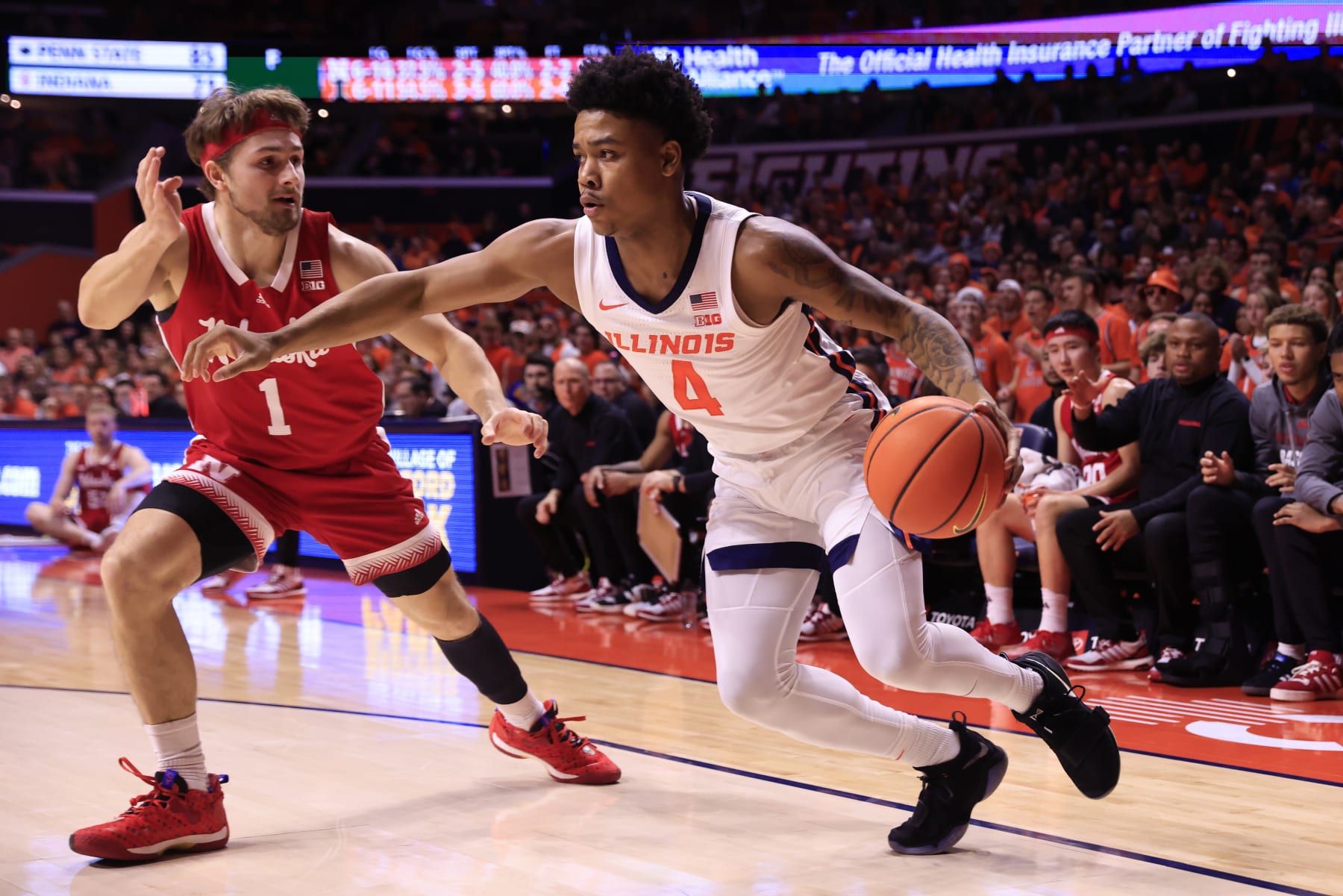 CHAMPAIGN, ILLINOIS - FEBRUARY 04: Justin Harmon #4 of the Illinois Fighting Illini drives to the basket while defended by Sam Hoiberg #1 of the Nebraska Cornhuskers at State Farm Center on February 04, 2024 in Champaign, Illinois. (Photo by Justin Casterline/Getty Images)