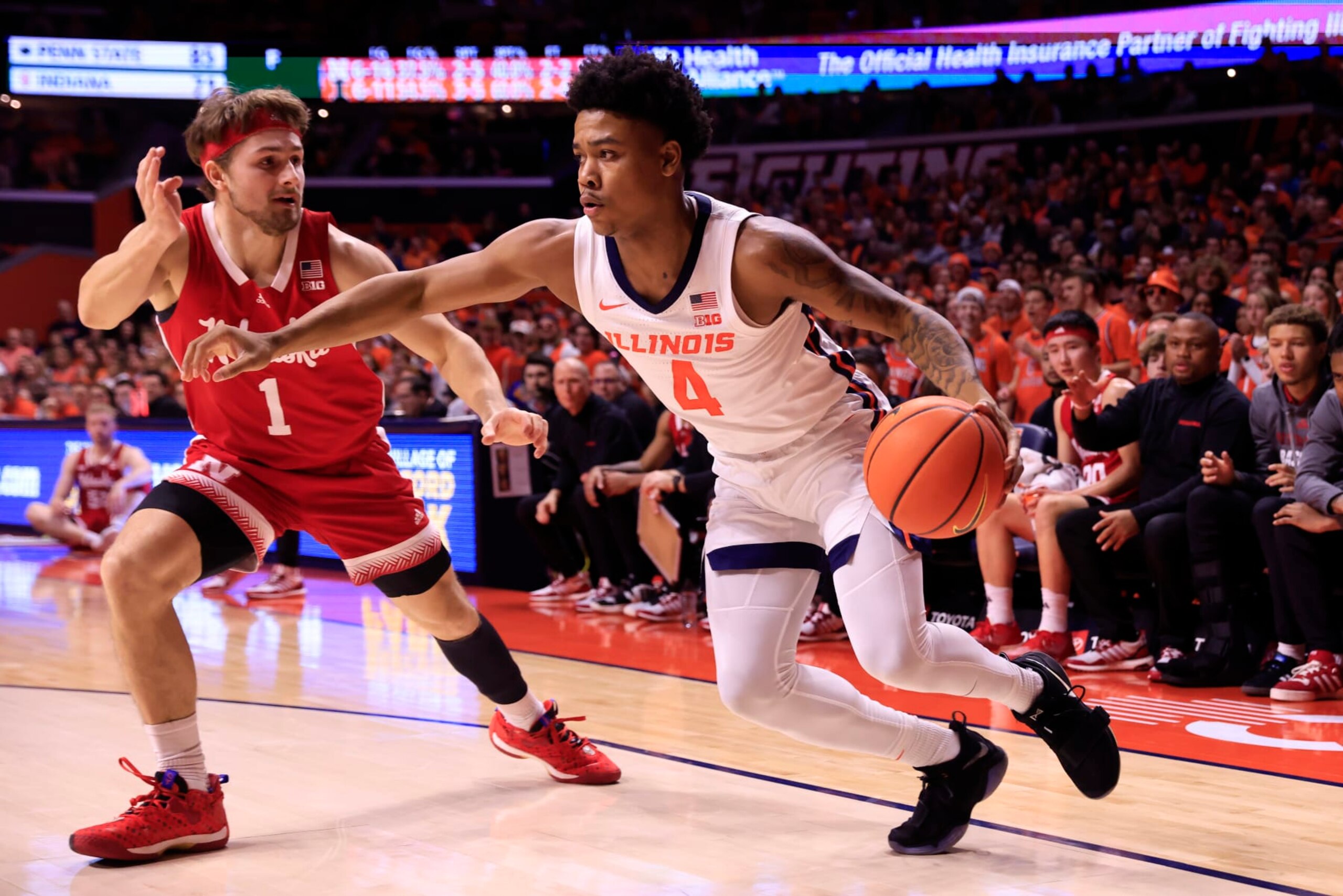 CHAMPAIGN, ILLINOIS - FEBRUARY 04: Justin Harmon #4 of the Illinois Fighting Illini drives to the basket while defended by Sam Hoiberg #1 of the Nebraska Cornhuskers at State Farm Center on February 04, 2024 in Champaign, Illinois. (Photo by Justin Casterline/Getty Images)