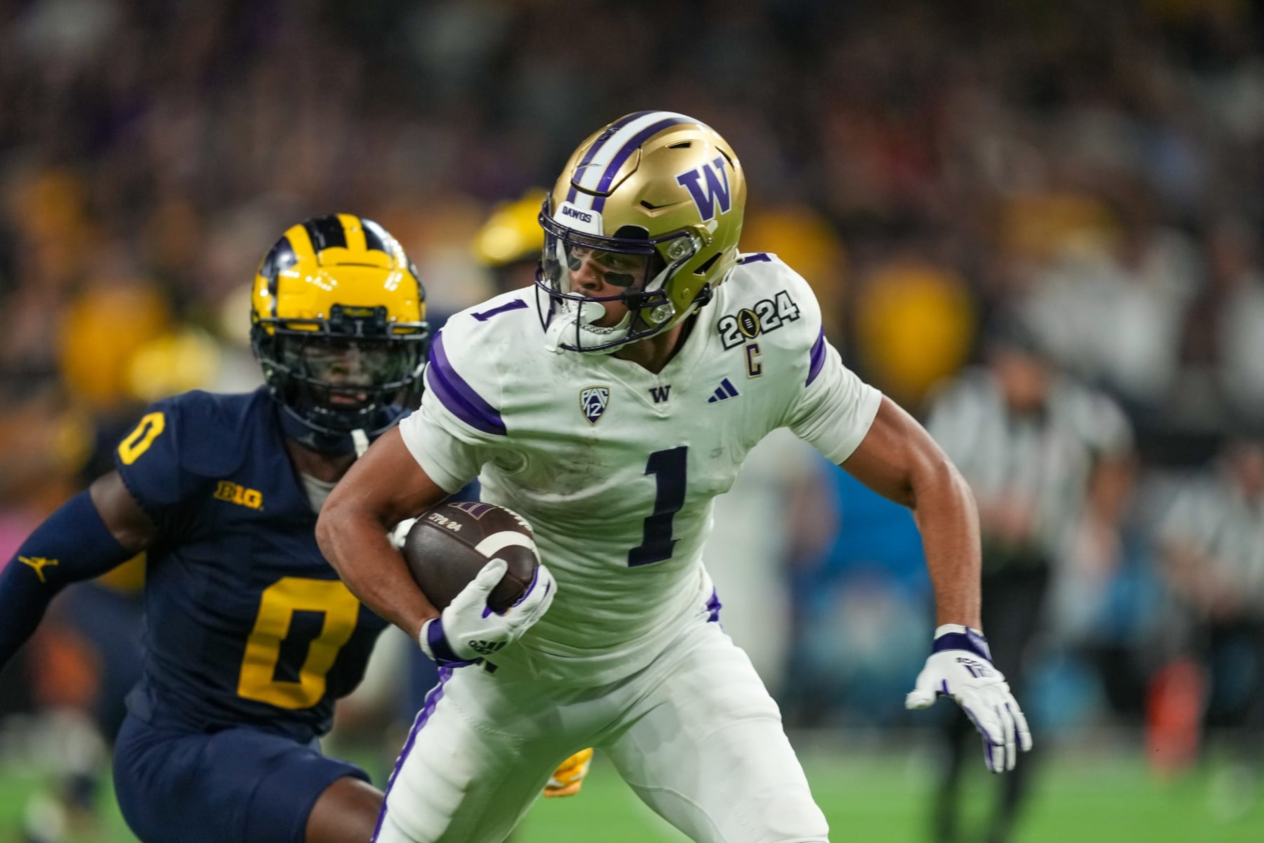 HOUSTON, TX - JANUARY 08: Washington Huskies wide receiver Rome Odunze (1) runs in front of Michigan Wolverines defensive back Mike Sainristil (0) during the CFP National Championship game between the Michigan Wolverines and Washington Huskies on January 8, 2024 at NRG Stadium in Houston, Texas. (Photo by Daniel Dunn/Icon Sportswire via Getty Images)