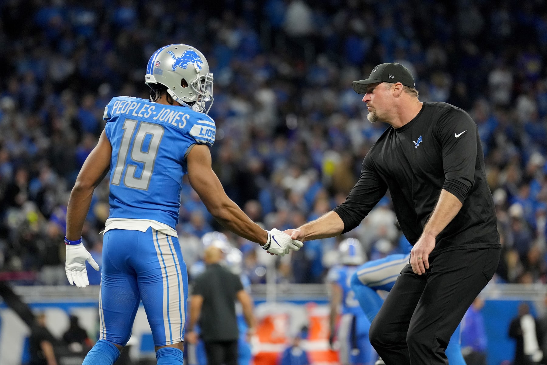 DETROIT, MICHIGAN - JANUARY 14: Donovan Peoples-Jones #19 of the Detroit Lions shakes hands with Head coach Dan Campbell prior to a game against the Los Angeles Rams in the NFC Wild Card Playoffs at Ford Field on January 14, 2024 in Detroit, Michigan. (Photo by Nic Antaya/Getty Images) DETROIT, MICHIGAN - JANUARY 14: Donovan Peoples-Jones #19 of the Detroit Lions shakes hands with Head coach Dan Campbell prior to a game against the Los Angeles Rams in the NFC Wild Card Playoffs at Ford Field on January 14, 2024 in Detroit, Michigan. (Photo by Nic Antaya/Getty Images)