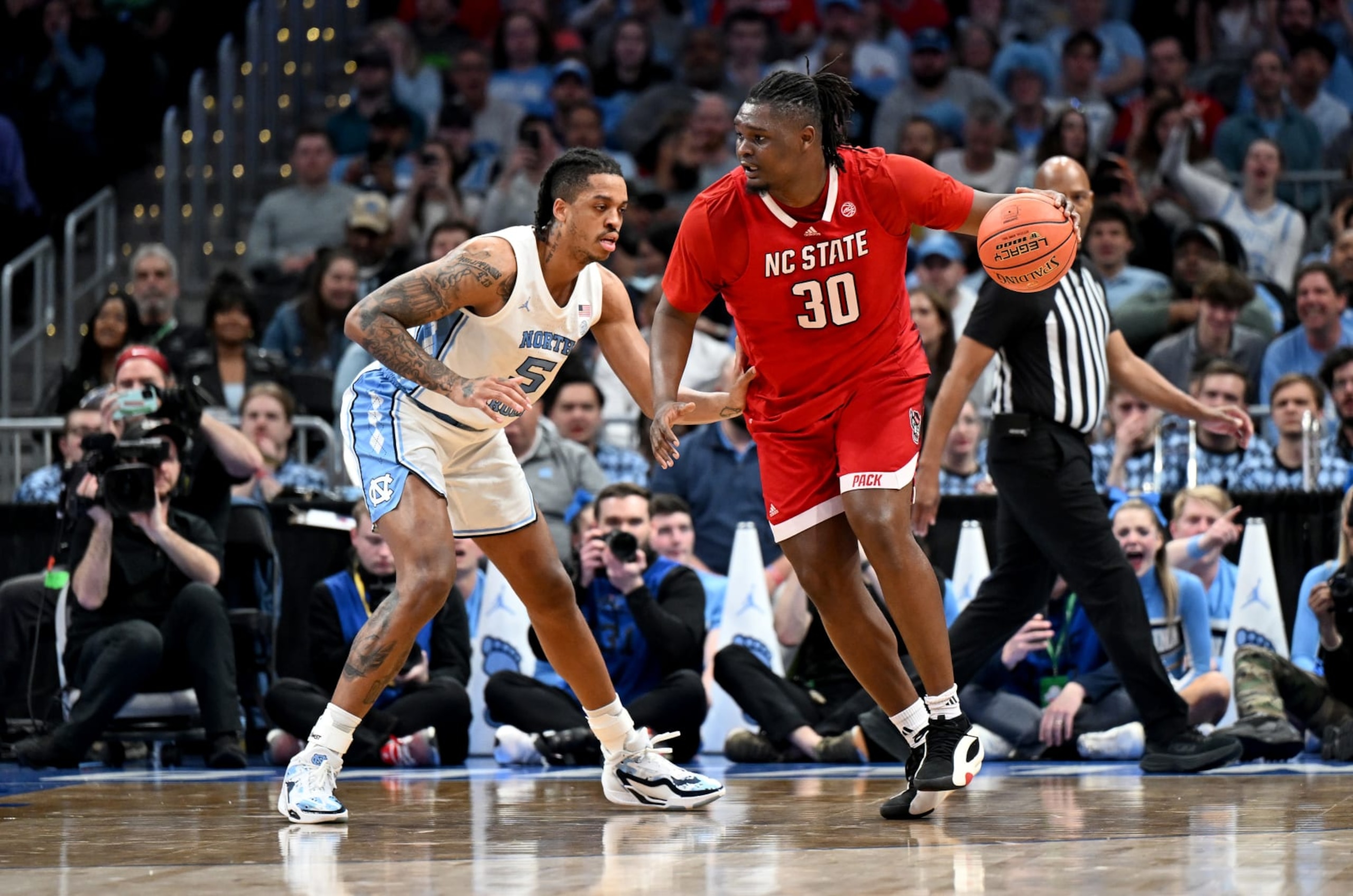 WASHINGTON, DC - MARCH 16: DJ Burns Jr. #30 of the North Carolina State Wolfpack handles the ball in the first half against Armando Bacot #5 of the North Carolina Tar Heels in the Championship Game of the ACC Men's Basketball Tournament  at Capital One Arena on March 16, 2024 in Washington, DC. (Photo by Greg Fiume/Getty Images)