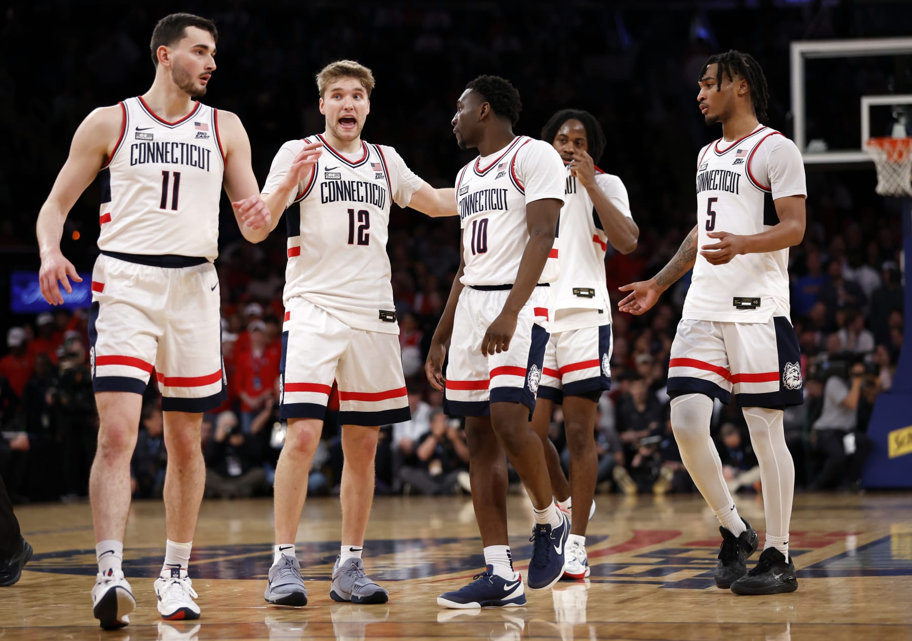 NEW YORK, NEW YORK - MARCH 15: Cam Spencer #12 talks with Alex Karaban #11 and Hassan Diarra #10 of the Connecticut Huskies in the second half against the St. John's Red Storm during the Semifinal round of the Big East Basketball Tournament at Madison Square Garden on March 15, 2024 in New York City. The Huskies won 95-90. (Photo by Sarah Stier/Getty Images)