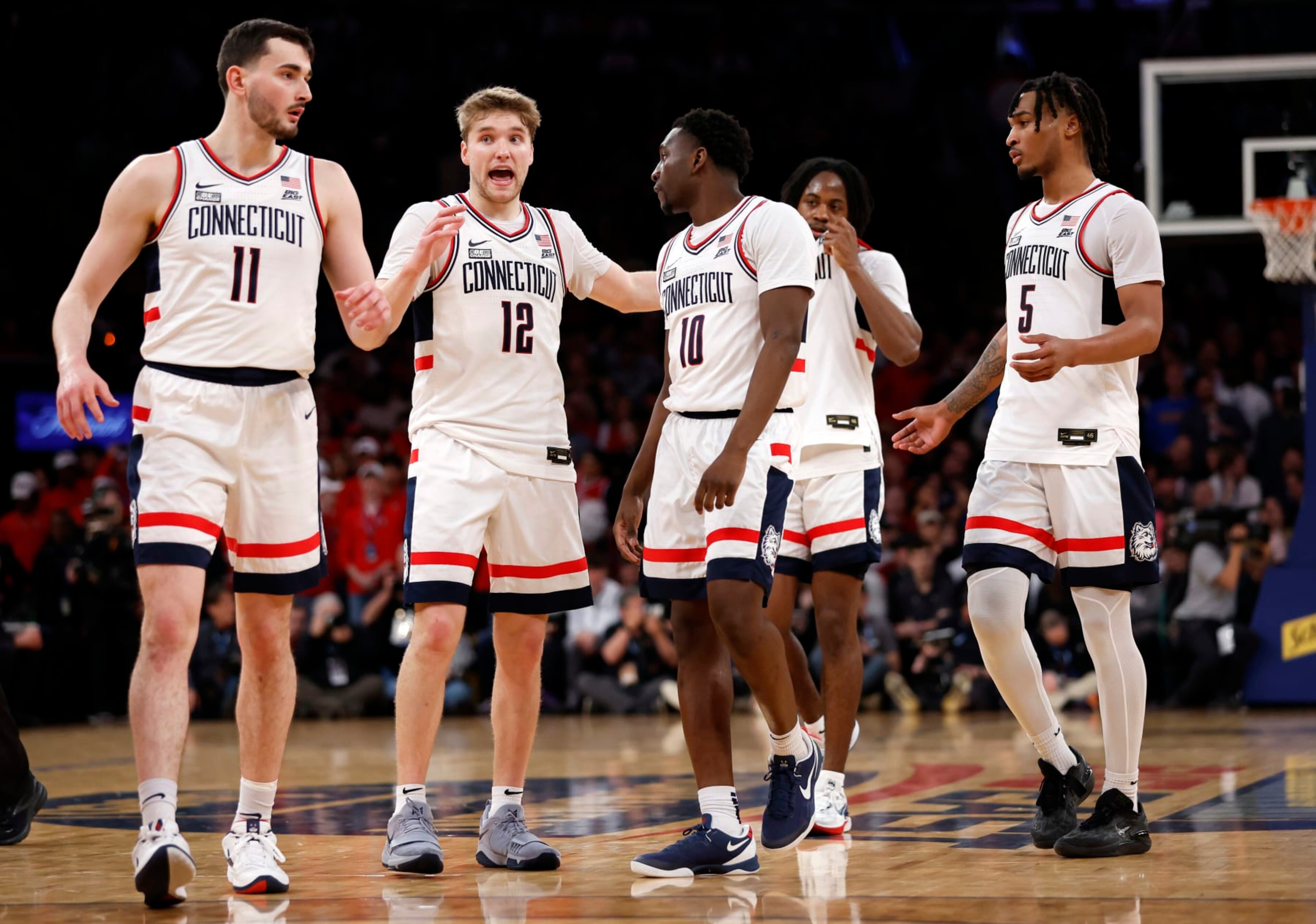 NEW YORK, NEW YORK - MARCH 15: Cam Spencer #12 talks with Alex Karaban #11 and Hassan Diarra #10 of the Connecticut Huskies in the second half against the St. John's Red Storm during the Semifinal round of the Big East Basketball Tournament at Madison Square Garden on March 15, 2024 in New York City. The Huskies won 95-90. (Photo by Sarah Stier/Getty Images) NEW YORK, NEW YORK - MARCH 15: Cam Spencer #12 talks with Alex Karaban #11 and Hassan Diarra #10 of the Connecticut Huskies in the second half against the St. John's Red Storm during the Semifinal round of the Big East Basketball Tournament at Madison Square Garden on March 15, 2024 in New York City. The Huskies won 95-90. (Photo by Sarah Stier/Getty Images)