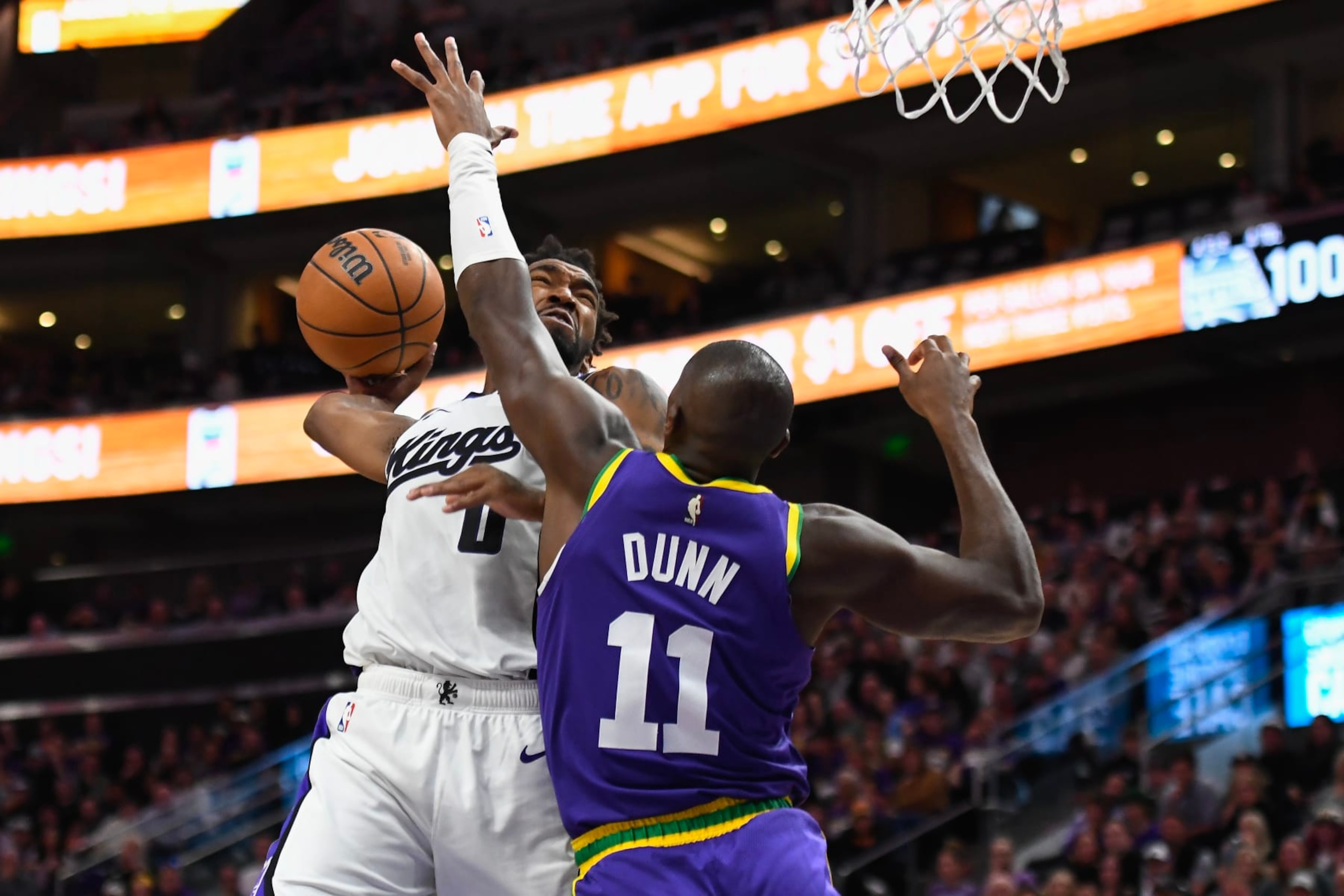 SALT LAKE CITY, UTAH - OCTOBER 25: Malik Monk #0 of the Sacramento Kings dunks over Kris Dunn #11 of the Utah Jazz during the second half of a game at Delta Center on October 25, 2023 in Salt Lake City, Utah. NOTE TO USER: User expressly acknowledges and agrees that, by downloading and or using this photograph, User is consenting to the terms and conditions of the Getty Images License Agreement. (Photo by Alex Goodlett/Getty Images)