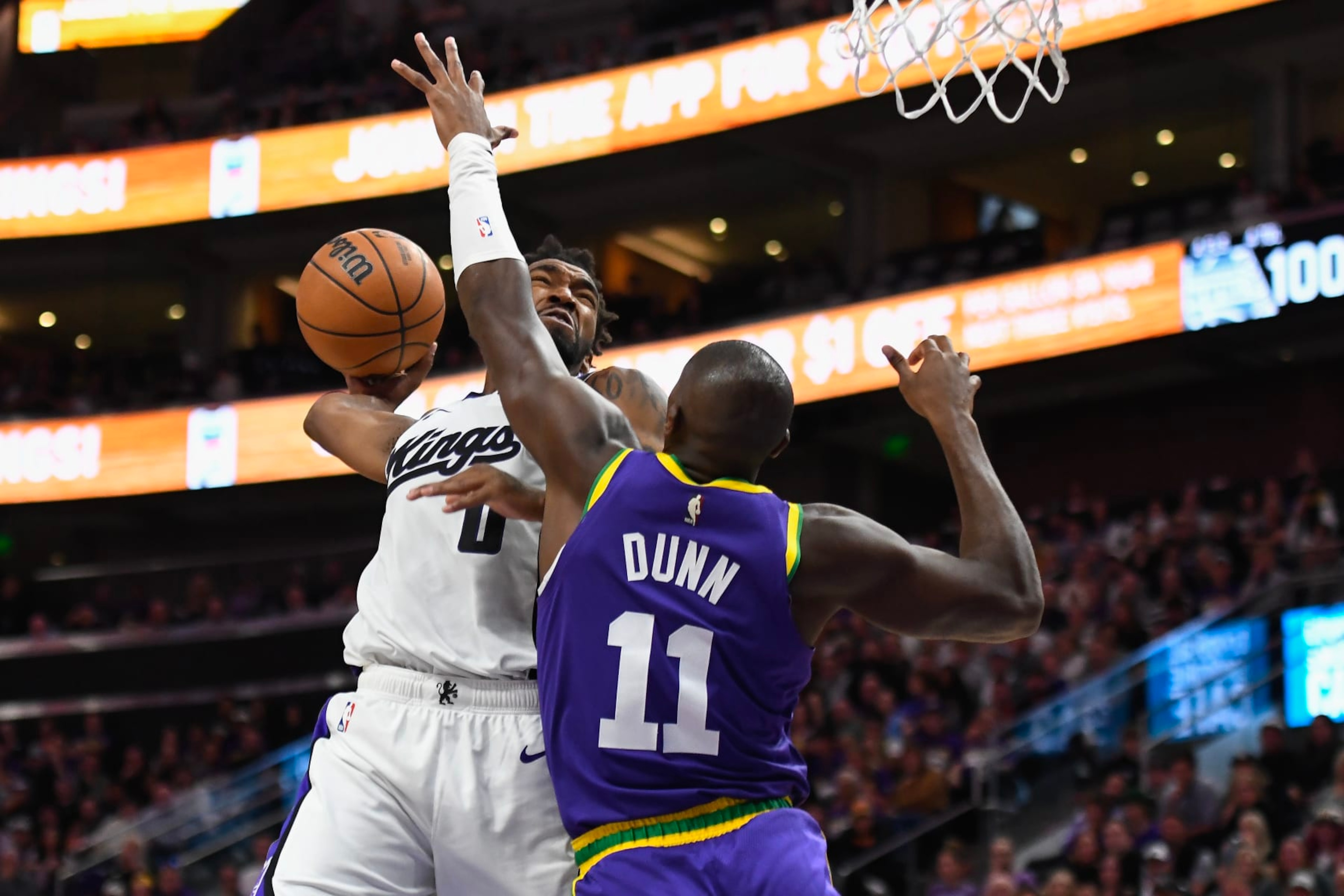 SALT LAKE CITY, UTAH - OCTOBER 25: Malik Monk #0 of the Sacramento Kings dunks over Kris Dunn #11 of the Utah Jazz during the second half of a game at Delta Center on October 25, 2023 in Salt Lake City, Utah. NOTE TO USER: User expressly acknowledges and agrees that, by downloading and or using this photograph, User is consenting to the terms and conditions of the Getty Images License Agreement. (Photo by Alex Goodlett/Getty Images)