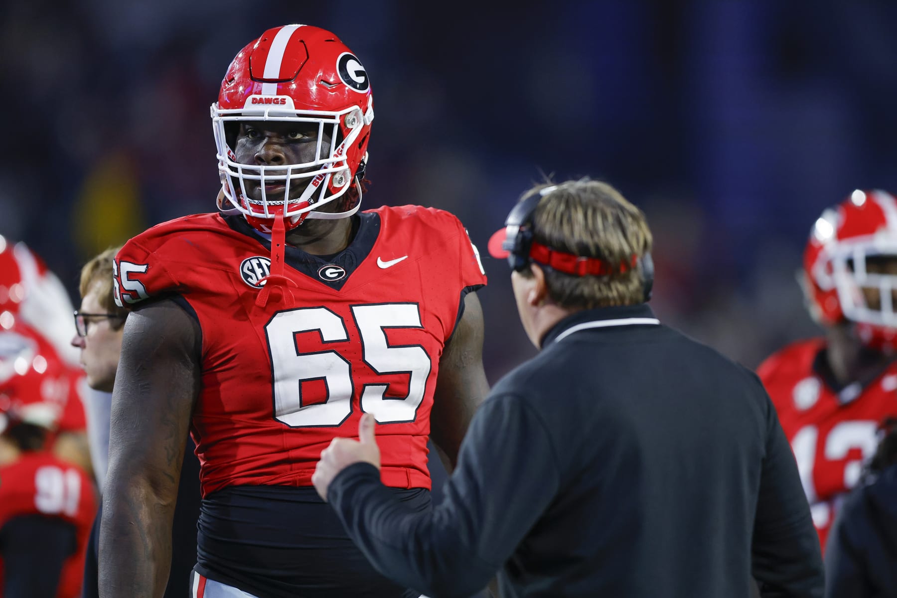 ATLANTA, GEORGIA - NOVEMBER 25: Amarius Mims #65 of the Georgia Bulldogs speaks with head coach Kirby Smart during the third quarter against the Georgia Tech Yellow Jackets at Bobby Dodd Stadium on November 25, 2023 in Atlanta, Georgia. (Photo by Todd Kirkland/Getty Images)
