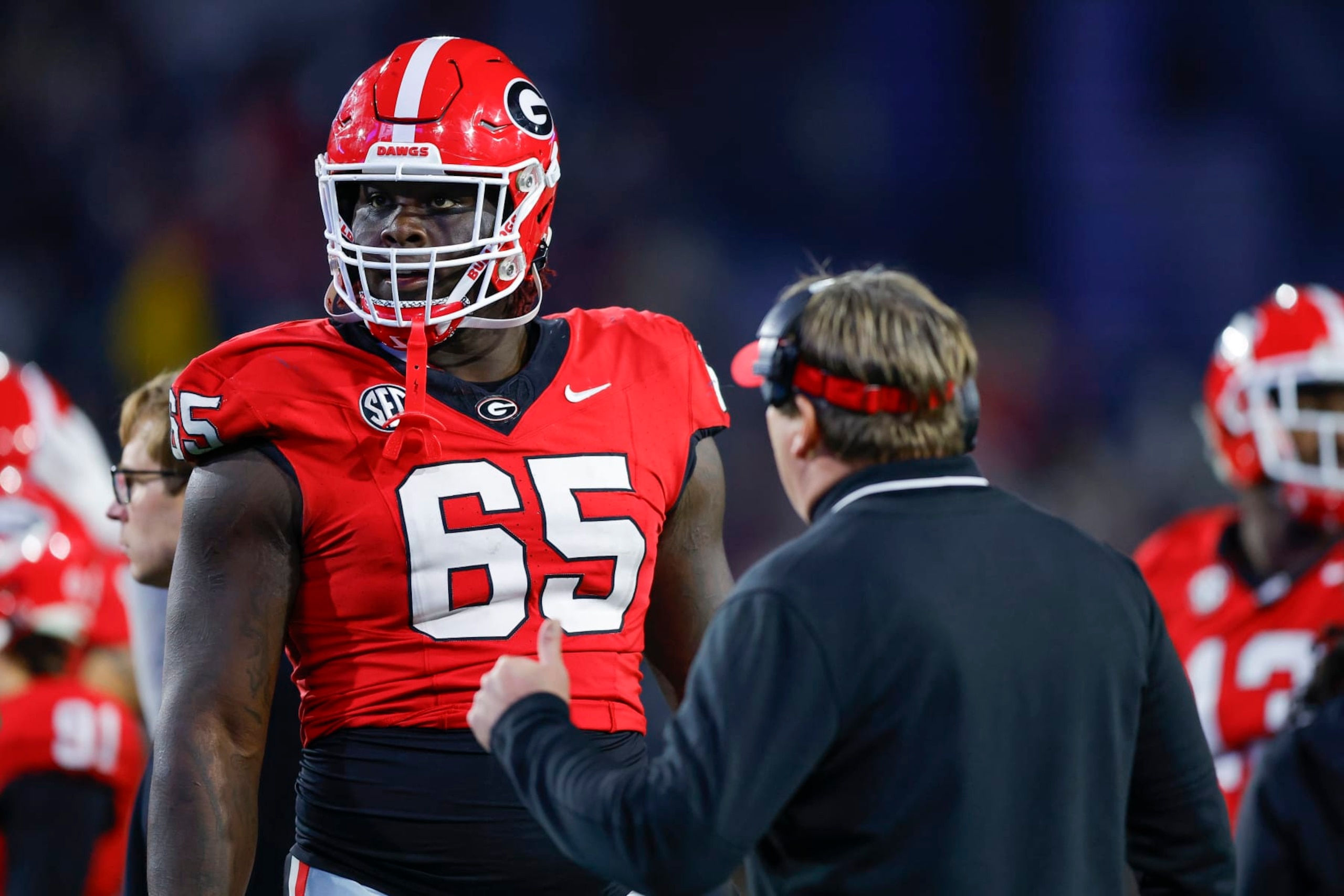 ATLANTA, GEORGIA - NOVEMBER 25: Amarius Mims #65 of the Georgia Bulldogs speaks with head coach Kirby Smart during the third quarter against the Georgia Tech Yellow Jackets at Bobby Dodd Stadium on November 25, 2023 in Atlanta, Georgia. (Photo by Todd Kirkland/Getty Images) ATLANTA, GEORGIA - NOVEMBER 25: Amarius Mims #65 of the Georgia Bulldogs speaks with head coach Kirby Smart during the third quarter against the Georgia Tech Yellow Jackets at Bobby Dodd Stadium on November 25, 2023 in Atlanta, Georgia. (Photo by Todd Kirkland/Getty Images)