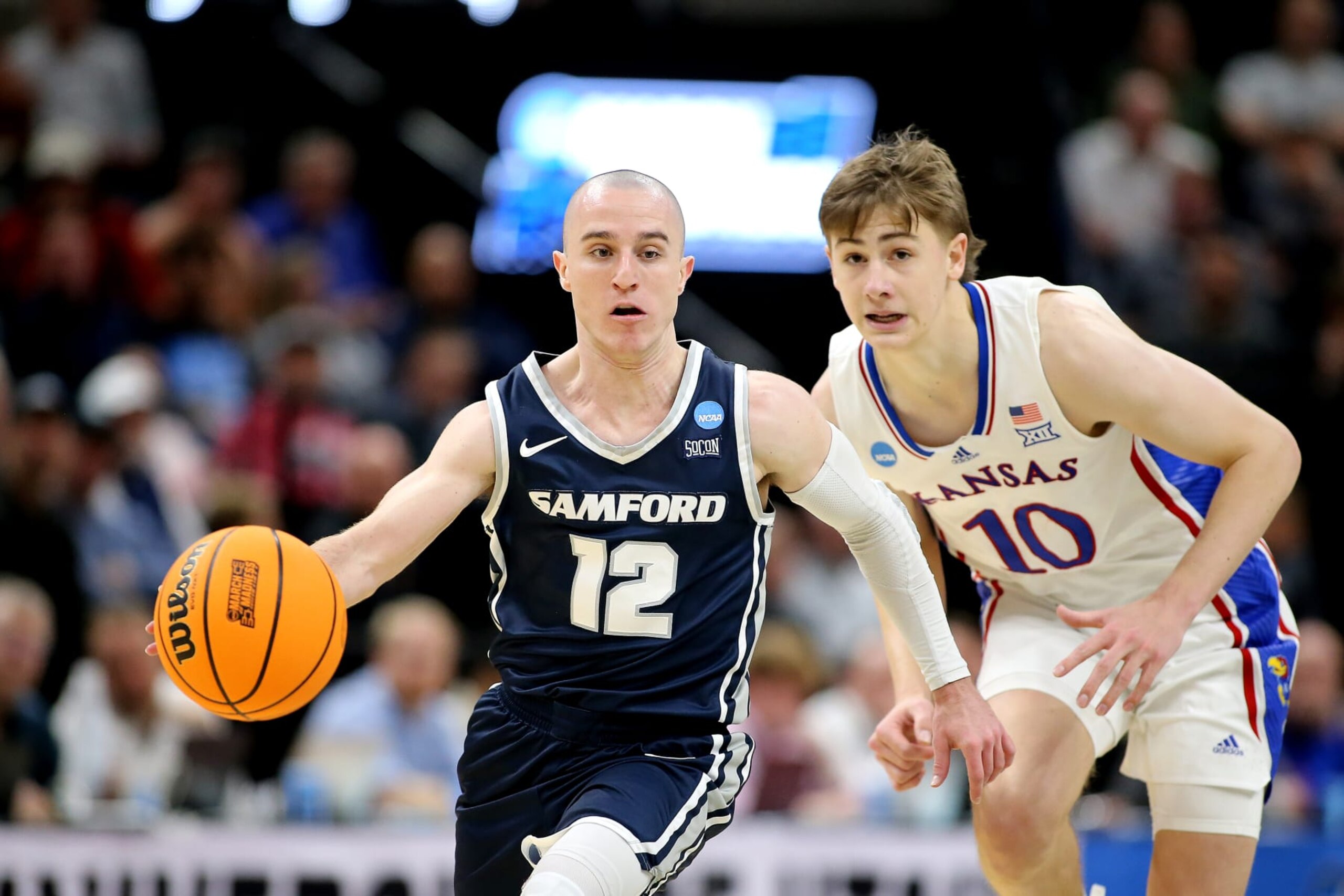 SALT LAKE CITY, UTAH - MARCH 21:  Dallas Graziani #12 of the Samford Bulldogs is pursued by Johnny Furphy #10 of the Kansas Jayhawks during the second half in the first round of the NCAA Men's Basketball Tournament at Delta Center on March 21, 2024 in Salt Lake City, Utah. (Photo by Chris Gardner/Getty Images)