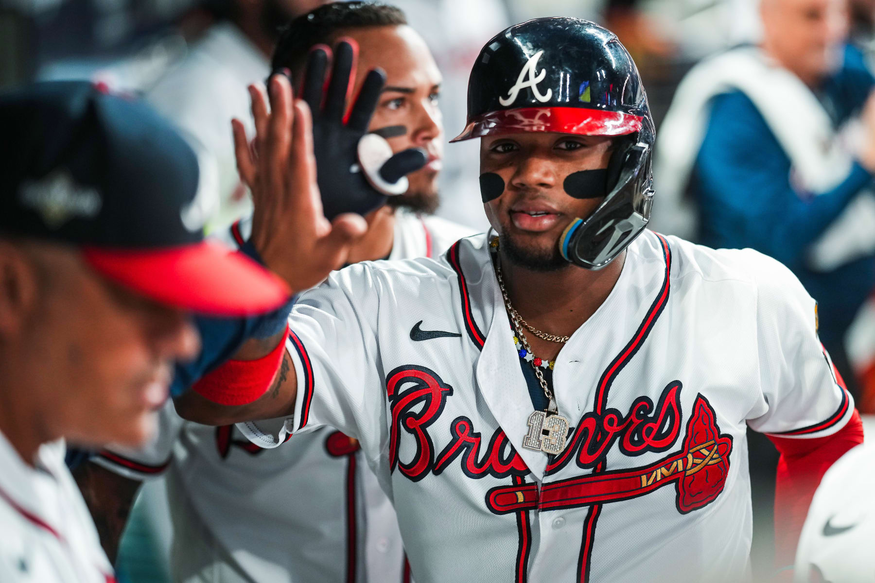 ATLANTA, GEORGIA - OCTOBER 9:  Ronald Acuna Jr. #13 of the Atlanta Braves is congratulated by teammates after scoring against the Philadelphia Phillies during the sixth inning in Game Two of the Division Series at Truist Park on October 9, 2023 in Atlanta, Georgia. (Photo by Kevin D. Liles/Atlanta Braves/Getty Images)