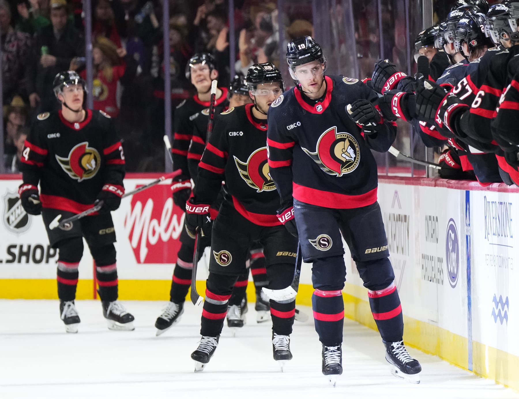 OTTAWA, CANADA - MARCH 1: Drake Batherson #19 of the Ottawa Senators celebrates his second period goal against the Arizona Coyotes with teammates at the players' bench at Canadian Tire Centre on March 1, 2024 in Ottawa, Ontario, Canada.  (Photo by Andrea Cardin/NHLI via Getty Images)