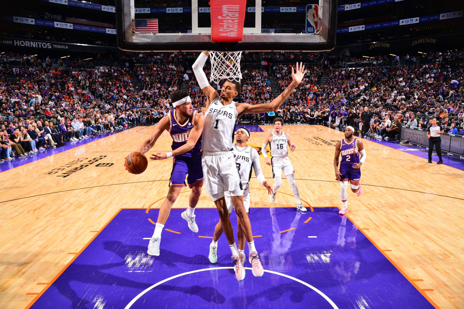 PHOENIX, AZ - NOVEMBER 2: Devin Booker #1 of the Phoenix Suns drives to the basket while Victor Wembanyama #1 of the San Antonio Spurs goes for the block during the game on November 2, 2023 at Footprint Center in Phoenix, Arizona. NOTE TO USER: User expressly acknowledges and agrees that, by downloading and or using this photograph, user is consenting to the terms and conditions of the Getty Images License Agreement. Mandatory Copyright Notice: Copyright 2023 NBAE (Photo by Barry Gossage/NBAE via Getty Images)
