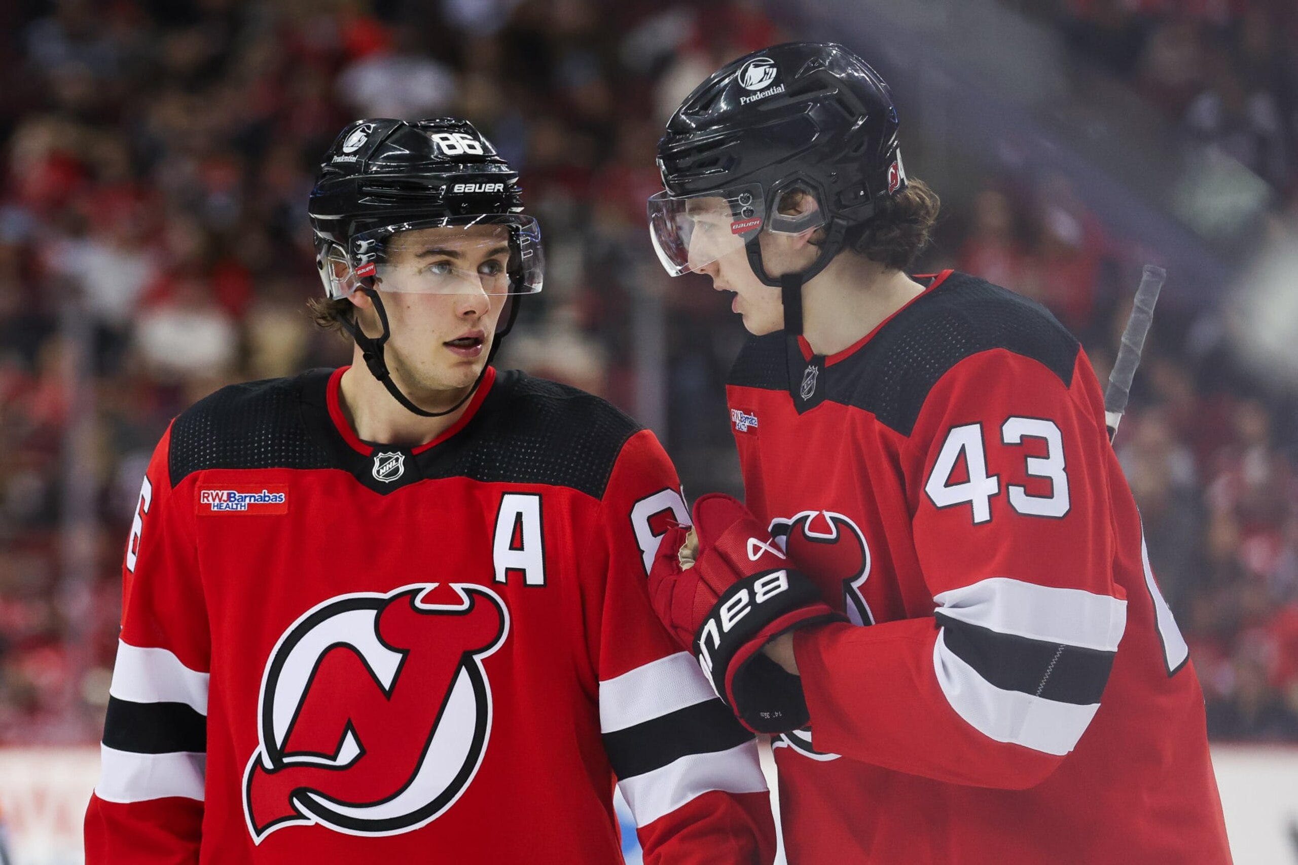 NEWARK, NJ - MARCH 21: New Jersey Devils center Jack Hughes (86) chats with New Jersey Devils defenseman Luke Hughes (43) during a game between the Winnipeg Jets and New Jersey Devils on March 21, 2024 at Prudential Center in the Newark, New Jersey. (Photo by Andrew Mordzynski/Icon Sportswire via Getty Images)
