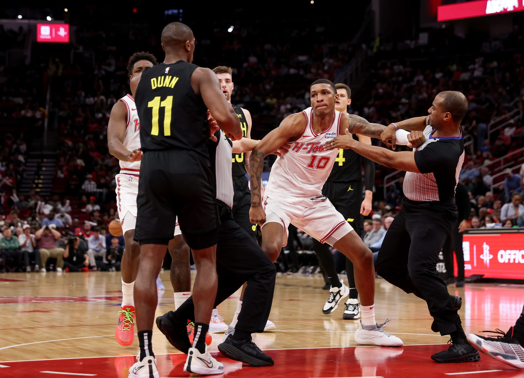 HOUSTON, TEXAS - MARCH 23: Jabari Smith Jr. #10 of the Houston Rockets and Kris Dunn #11 of the Utah Jazz are separated on the court in the first half at Toyota Center on March 23, 2024 in Houston, Texas.  NOTE TO USER: User expressly acknowledges and agrees that, by downloading and or using this photograph, User is consenting to the terms and conditions of the Getty Images License Agreement. (Photo by Tim Warner/Getty Images)