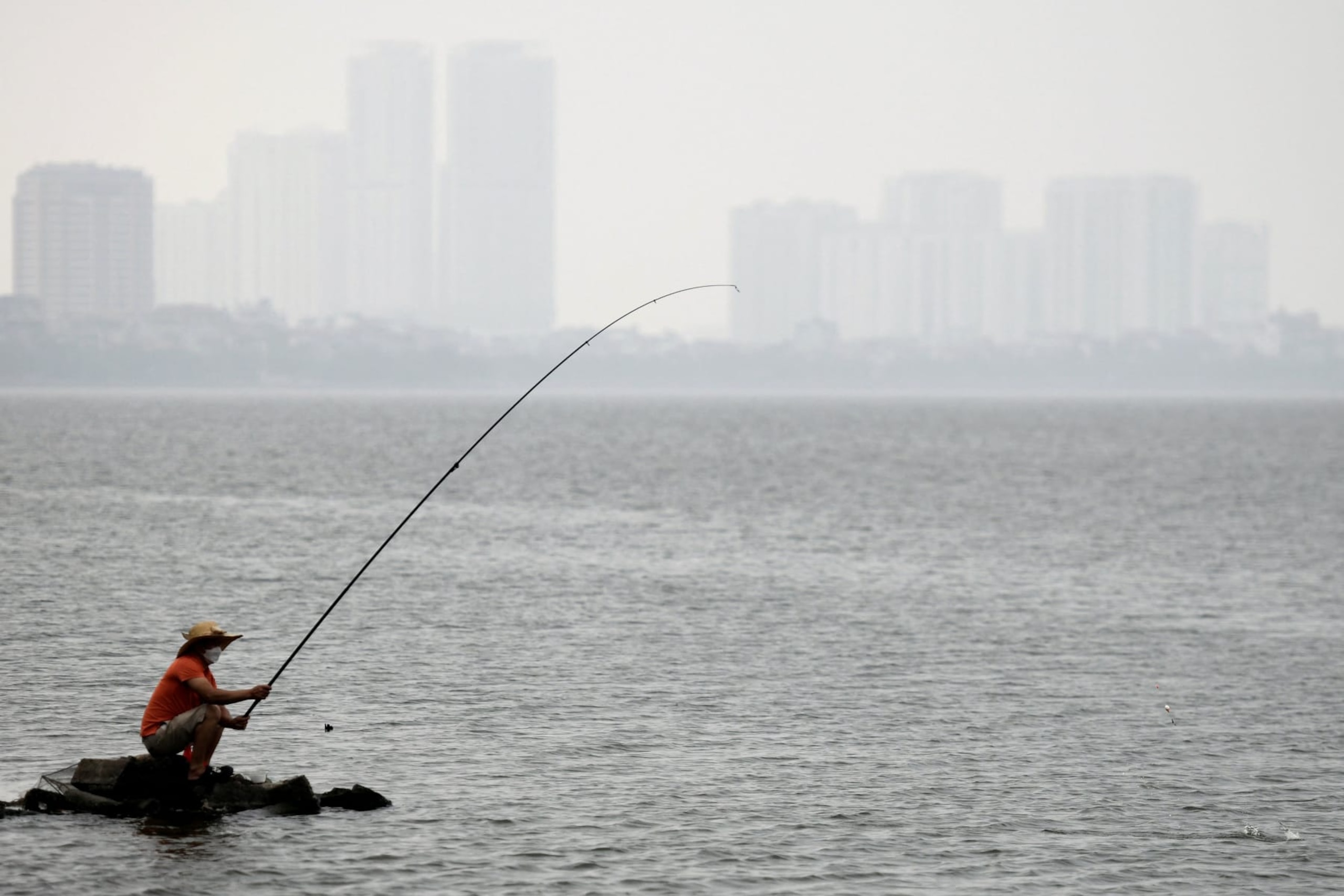 A man fishes in West Lake in Hanoi on April 18, 2023. (Photo by Nhac NGUYEN / AFP) (Photo by NHAC NGUYEN/AFP via Getty Images)