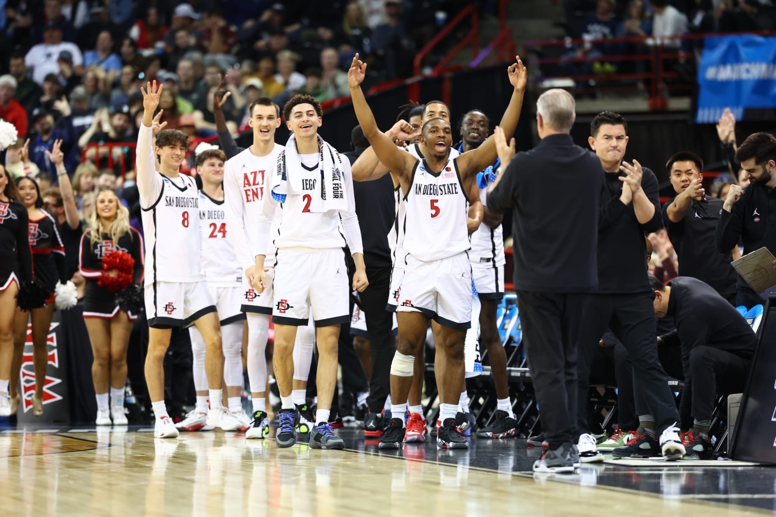 SPOKANE, WASHINGTON - MARCH 24: Lamont Butler #5 and bench players of the San Diego State Aztecs celebrate in the first half against Yale Bulldogs during the second round of the 2024 NCAA Men's Basketball Tournament held at Spokane Veterans Memorial Arena on March 24, 2024 in Spokane, Washington. (Photo by C. Morgan Engel/NCAA Photos via Getty Images)