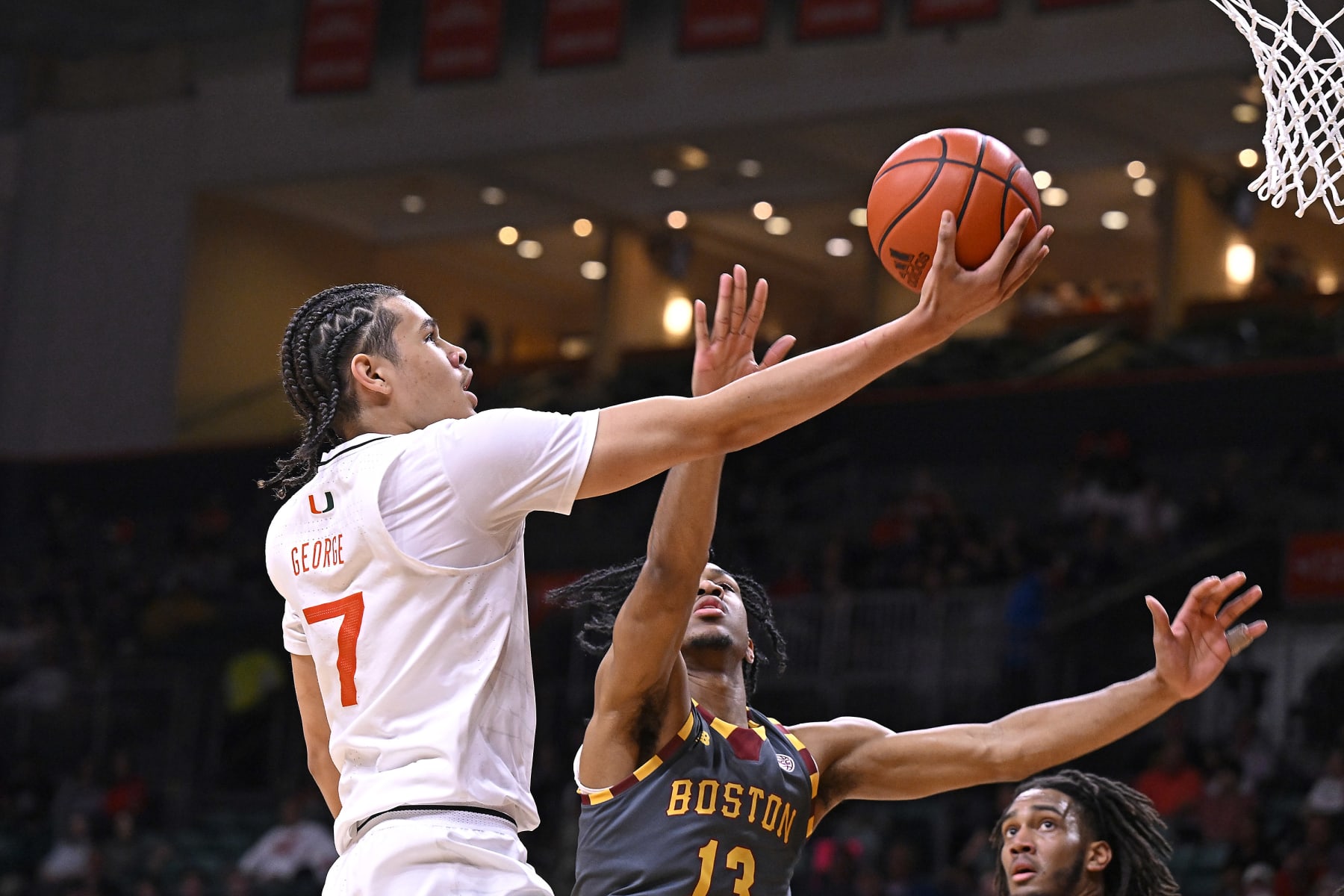 CORAL GABLES, FL - MARCH 06: Miami guard Kyshawn George (7) puts up a basket while defended by Boston College guard Donald Hand Jr. (13) in the first half as the Miami Hurricanes faced the Boston College Eagles on March 6, 2024, at the Watsco Center in Coral Gables, Florida. (Photo by Samuel Lewis/Icon Sportswire via Getty Images)