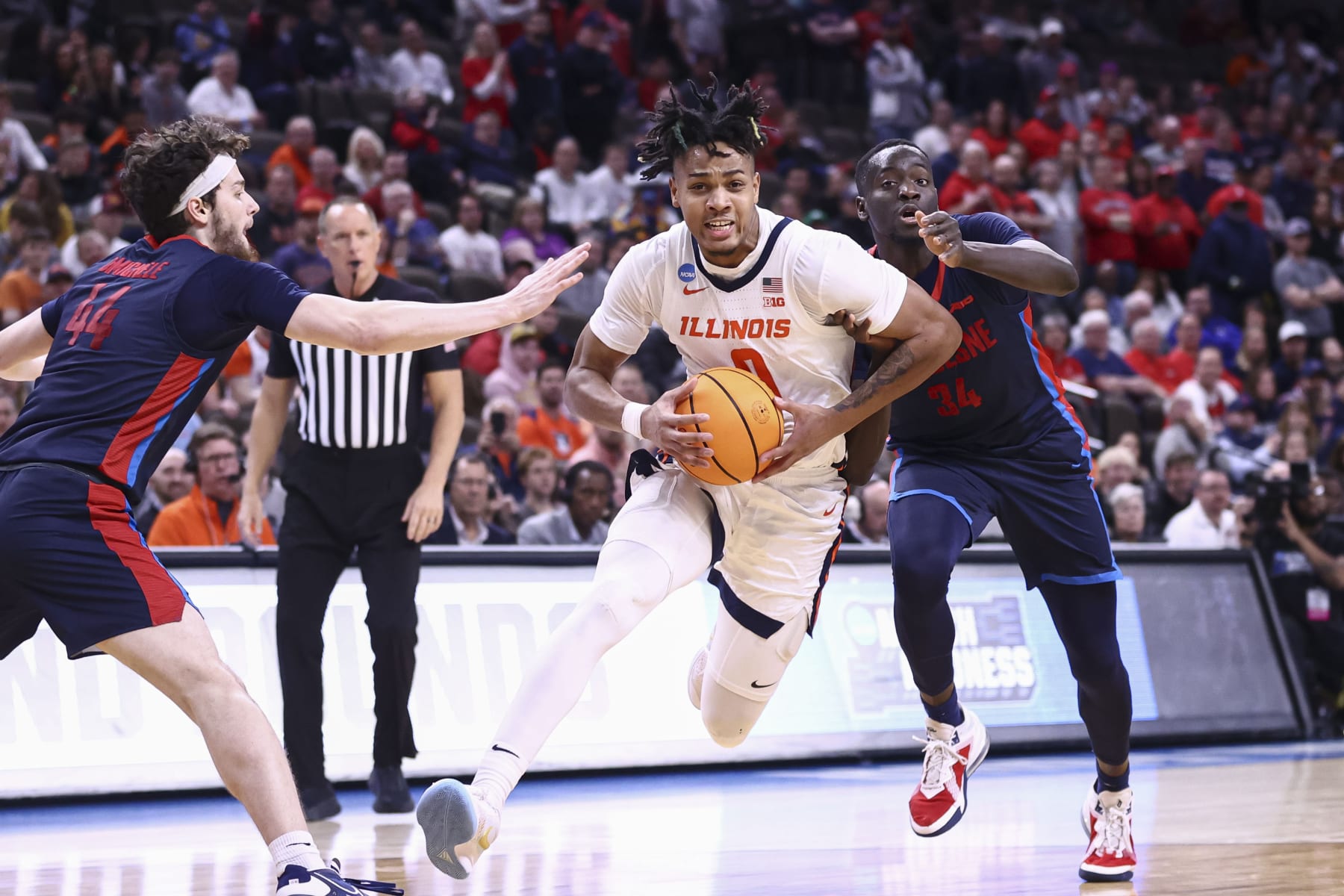 OMAHA, NEBRASKA - MARCH 23: Terrence Shannon Jr. #0 of the Illinois Fighting Illini dribbles the ball through Jake DiMichele #44 and Fousseyni Drame #34 of the Duquesne Dukes in the second half of the game during the second round of the 2024 NCAA Men's Basketball Tournament held at CHI Health Center on March 23, 2024 in Omaha, Nebraska. (Photo by Tyler Schank/NCAA Photos via Getty Images)