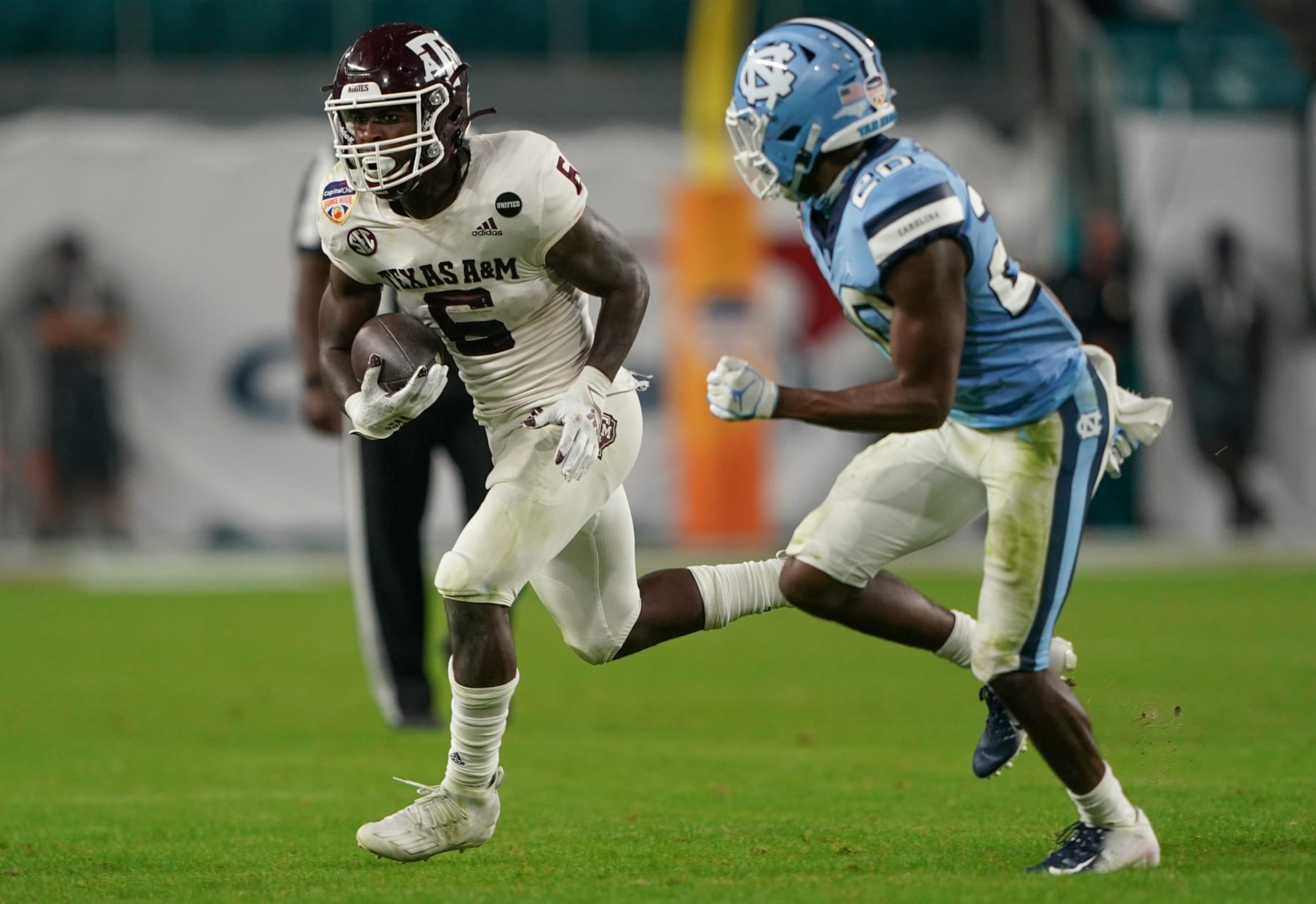 MIAMI GARDENS, FLORIDA - JANUARY 02: Devon Achane #6 of the Texas A&M Aggies runs with the ball against Tony Grimes #20 of the North Carolina Tar Heels in the third quarter of the Capital One Orange Bowl at Hard Rock Stadium on January 02, 2021 in Miami Gardens, Florida. (Photo by Mark Brown/Getty Images)