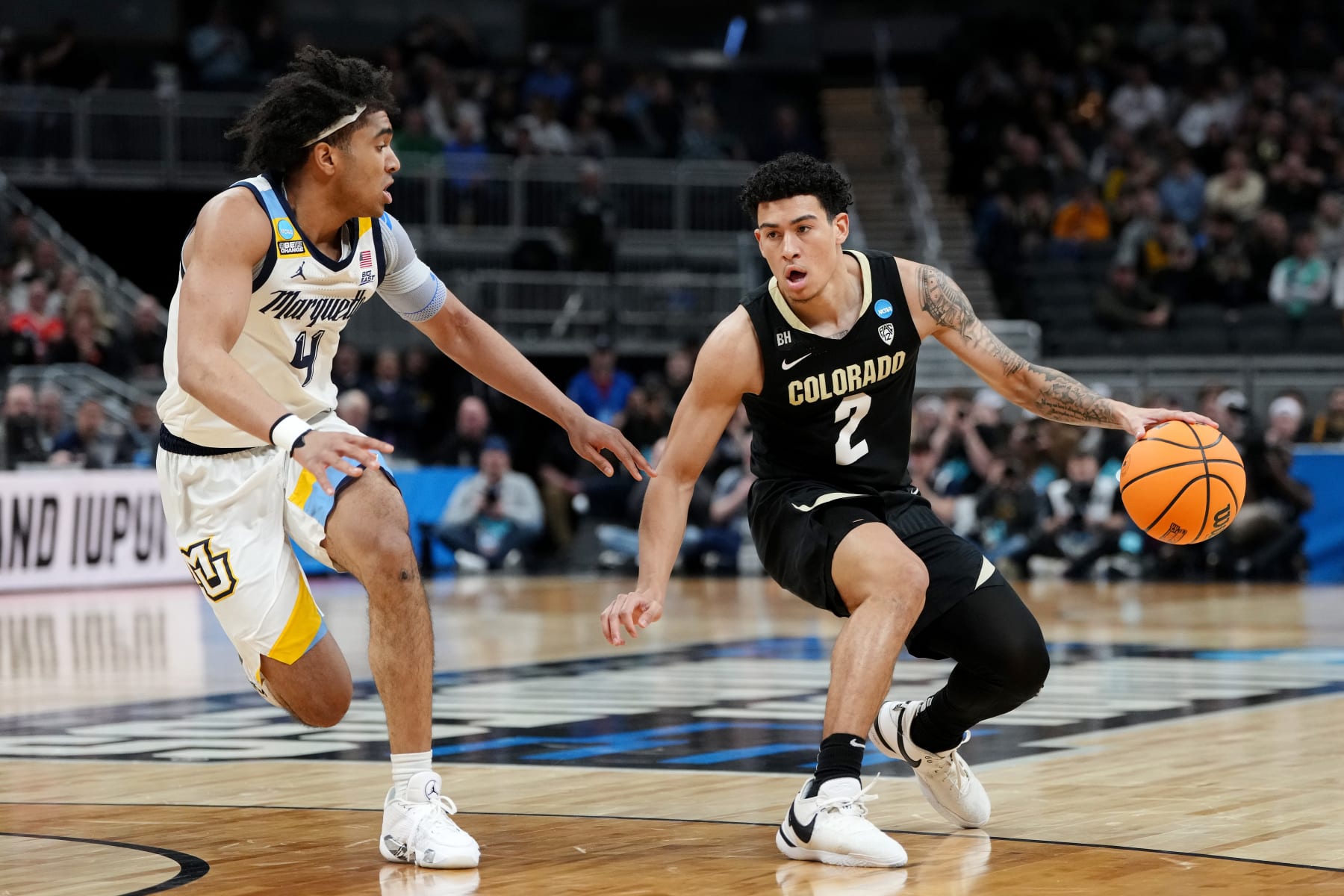 INDIANAPOLIS, INDIANA - MARCH 24: KJ Simpson #2 of the Colorado Buffaloes dribbles against Stevie Mitchell #4 of the Marquette Golden Eagles during the first half in the second round of the NCAA Men's Basketball Tournament at Gainbridge Fieldhouse on March 24, 2024 in Indianapolis, Indiana. (Photo by Dylan Buell/Getty Images)