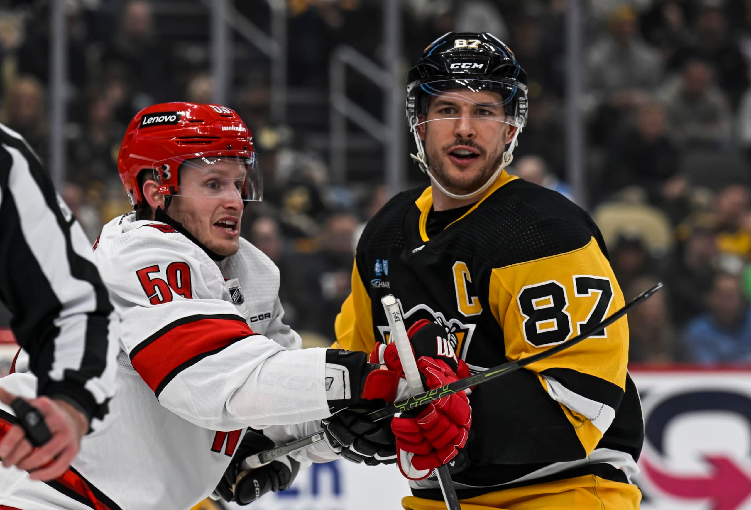 PITTSBURGH, PA - MARCH 26: Pittsburgh Penguins center Sidney Crosby (87) and Carolina Hurricanes left wing Jake Guentzel (59) face-off during the first period in the NHL game between the Pittsburgh Penguins and the Carolina Hurricanes on March 26, 2024, at PPG Paints Arena in Pittsburgh, PA. (Photo by Jeanine Leech/Icon Sportswire via Getty Images)