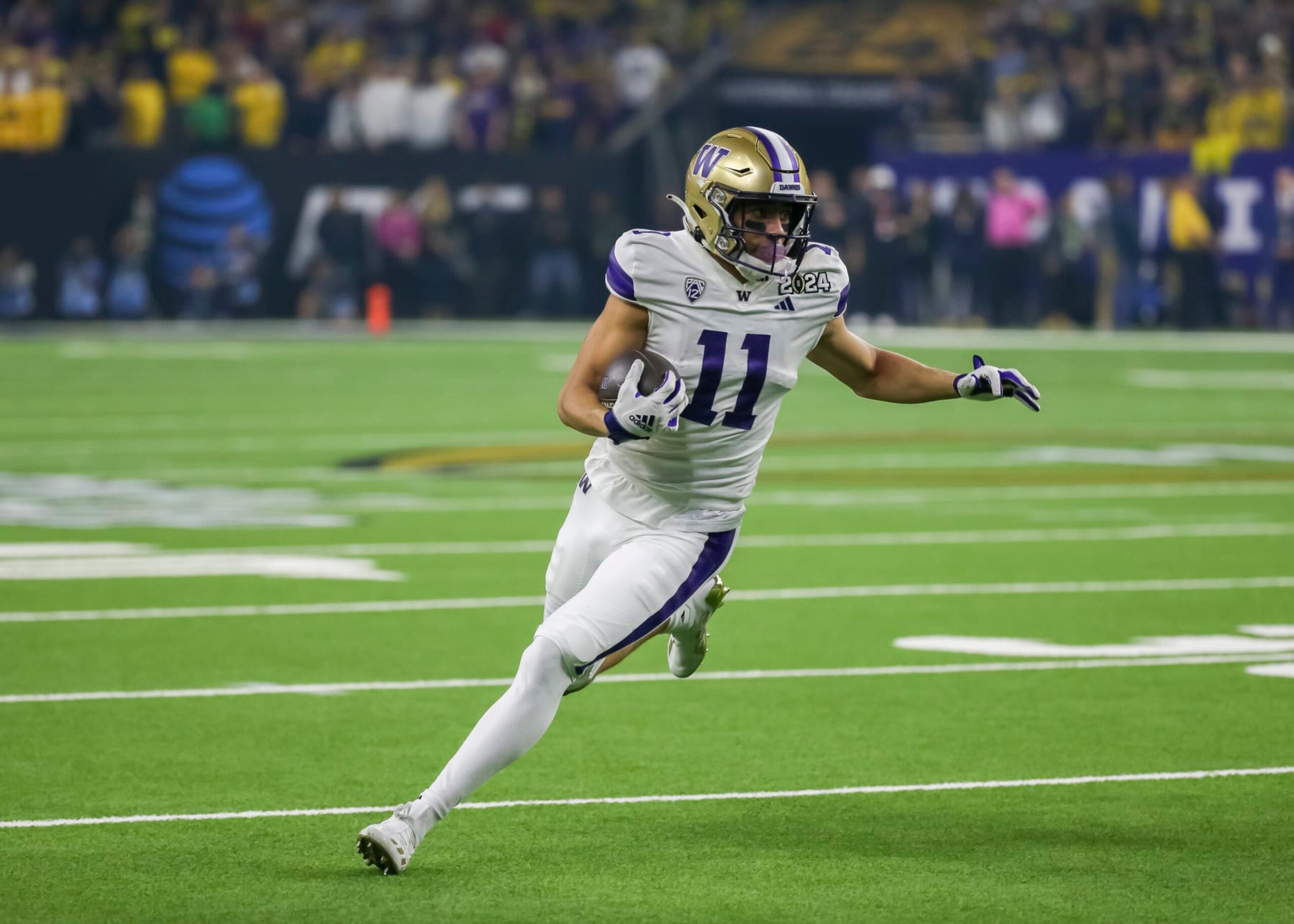 HOUSTON, TX - JANUARY 08:  Washington Huskies wide receiver Jalen McMillan (11) carries the ball in the first quarter during the CFP National Championship game between the Michigan Wolverines and Washington Huskies on January 8, 2024 at NRG Stadium in Houston, Texas.  (Photo by Leslie Plaza Johnson/Icon Sportswire via Getty Images)