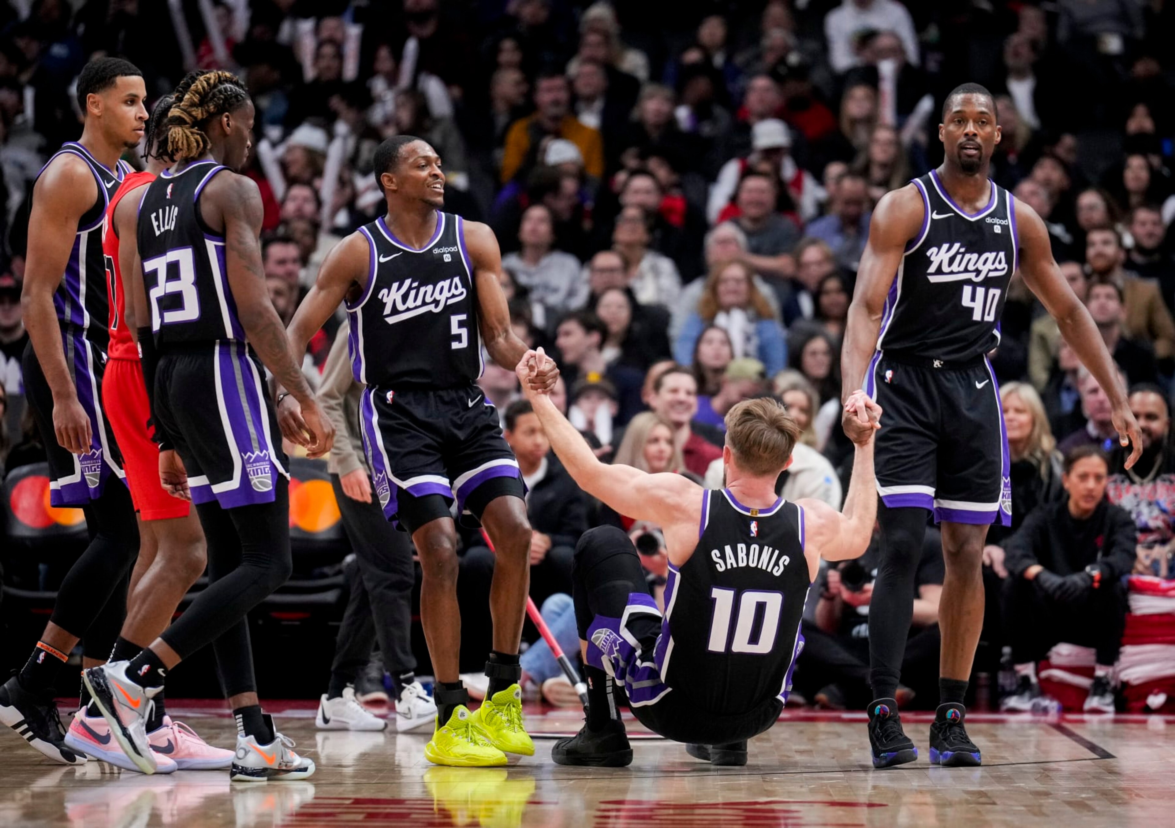 TORONTO, ON - MARCH 20: Domantas Sabonis #10 of the Sacramento Kings is helped up by teammates De'Aaron Fox #5 and Harrison Barnes #40 against the Toronto Raptors in the second half at the Scotiabank Arena on March 20, 2024 in Toronto, Ontario, Canada. NOTE TO USER: User expressly acknowledges and agrees that, by downloading and/or using this Photograph, user is consenting to the terms and conditions of the Getty Images License Agreement. (Photo by Mark Blinch/Getty Images)