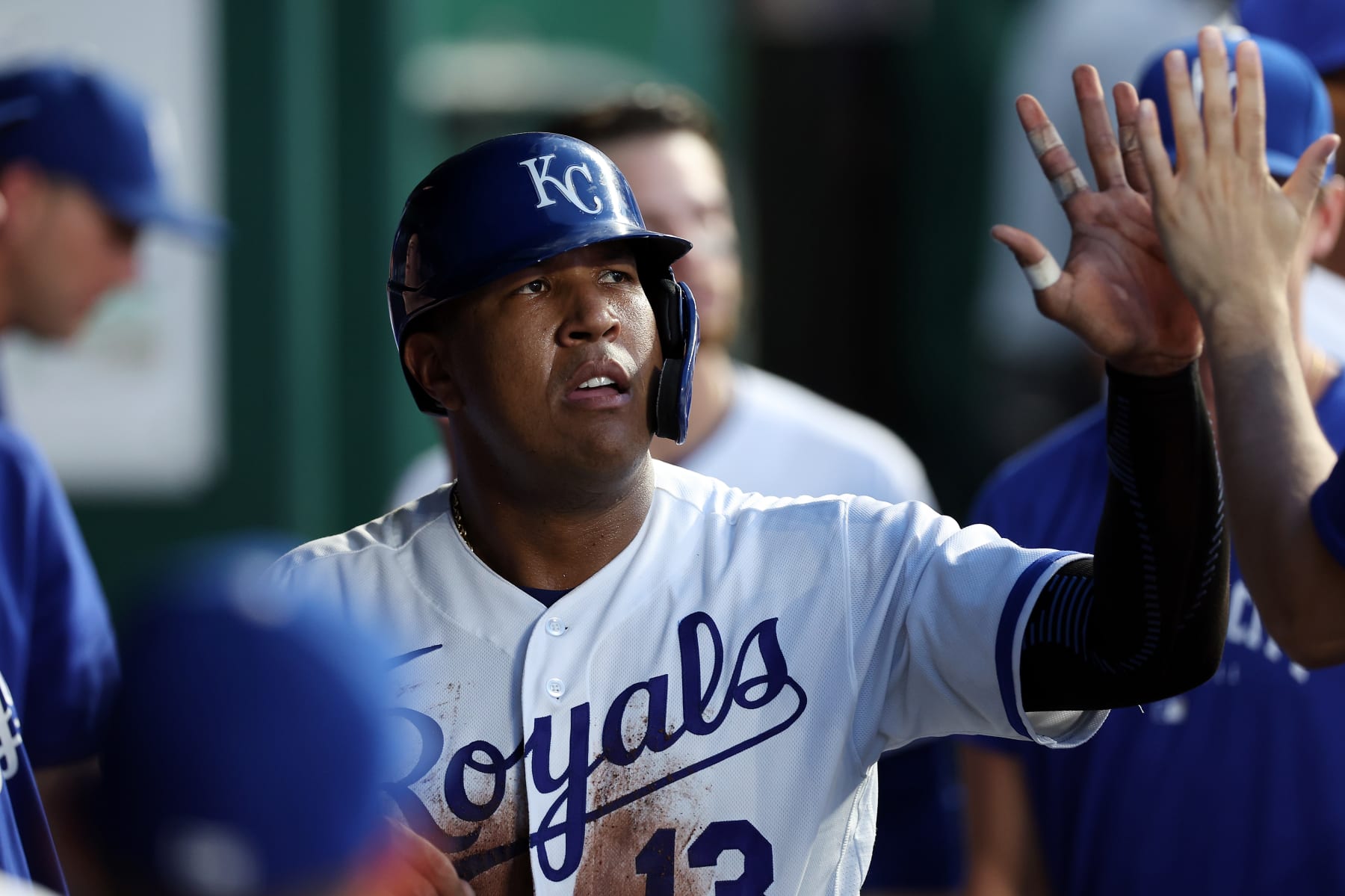 KANSAS CITY, MISSOURI - AUGUST 16:  Salvador Perez #13 of the Kansas City Royals is congratulated by teammates in the dugout after scoring during the 3rd inning of the game against the Seattle Mariners at Kauffman Stadium on August 16, 2023 in Kansas City, Missouri. (Photo by Jamie Squire/Getty Images)