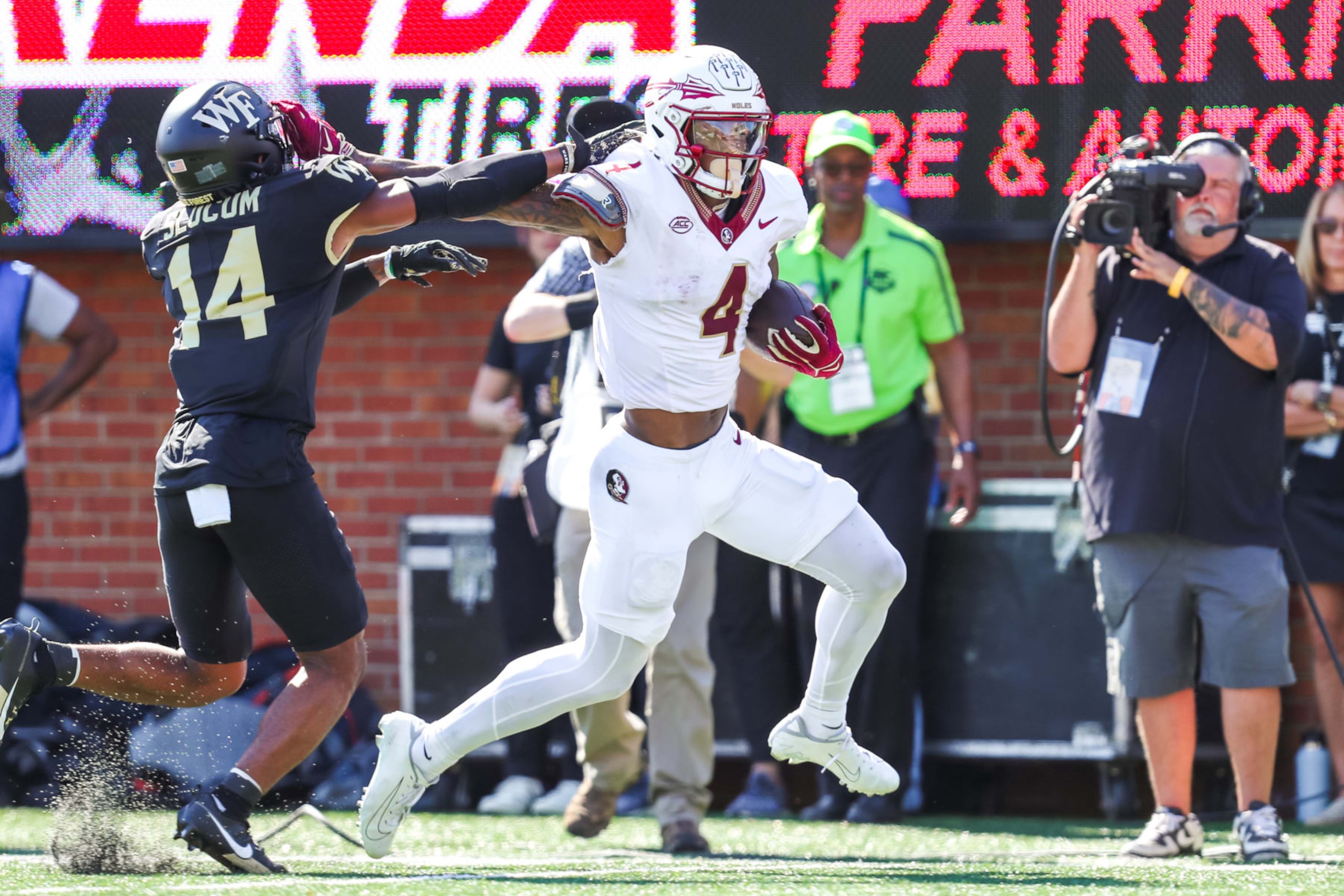 CHARLOTTE, NC - OCTOBER 28: Keon Coleman #4 of the Florida State Seminoles still arms Evan Slocum #14 of the Wake Forest Demon Deacons as he runs the ball during a football game at Allegacy Federal Credit Union Stadium in Winston-Salem, North Carolina on Oct 28, 2023. (Photo by David Jensen/Icon Sportswire via Getty Images)
