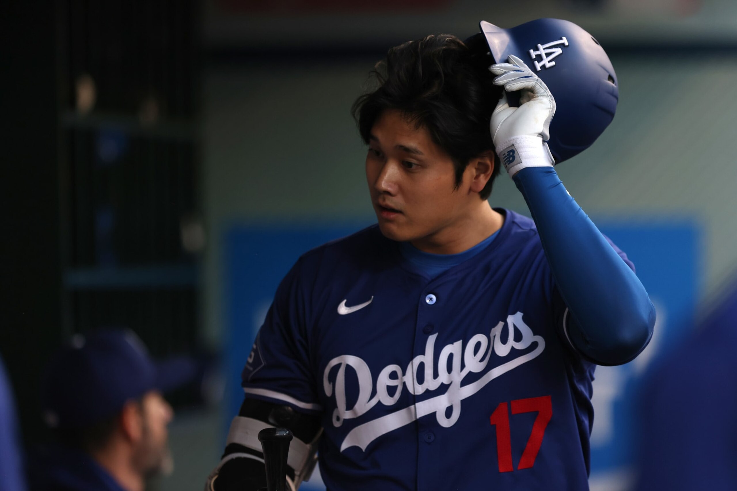 ANAHEIM, CALIFORNIA - MARCH 26: Shohei Ohtani #17 of the Los Angeles Dodgers removes his helmet in the dugout after striking out in the third inning during an exhibition game against the Los Angeles Angels at Angel Stadium of Anaheim on March 26, 2024 in Anaheim, California. (Photo by Katharine Lotze/Getty Images)
