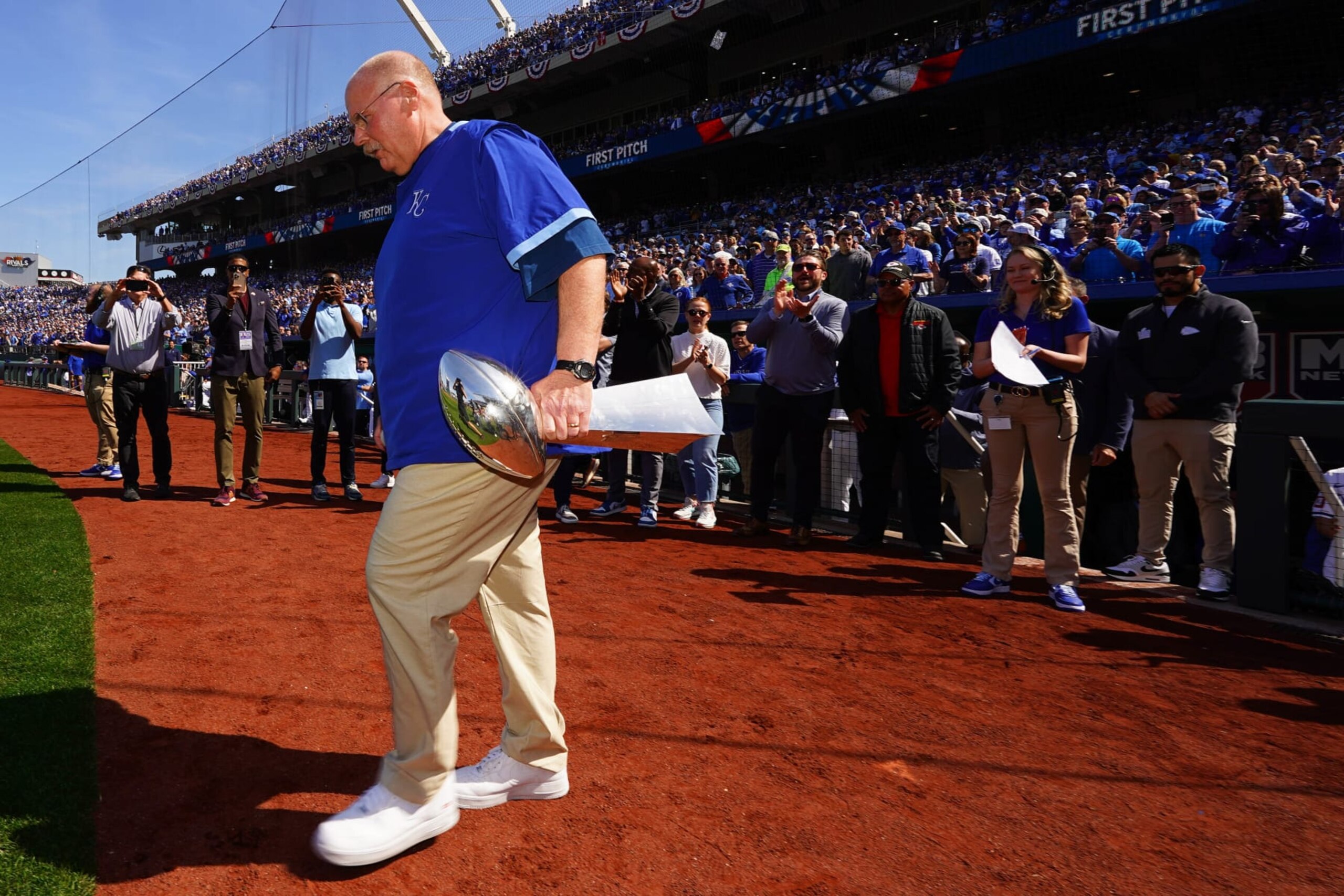 KANSAS CITY, MO - MARCH 28:  Head coach Andy Reid of the Kansas City Chiefs takes the field with the Lombardi Trophy to throw the ceremonial first pitch prior to the game between the Minnesota Twins and the Kansas City Royals at Kauffman Stadium on Thursday, March 28, 2024 in Kansas City, Missouri. (Photo by Kyle Rivas/MLB Photos via Getty Images)