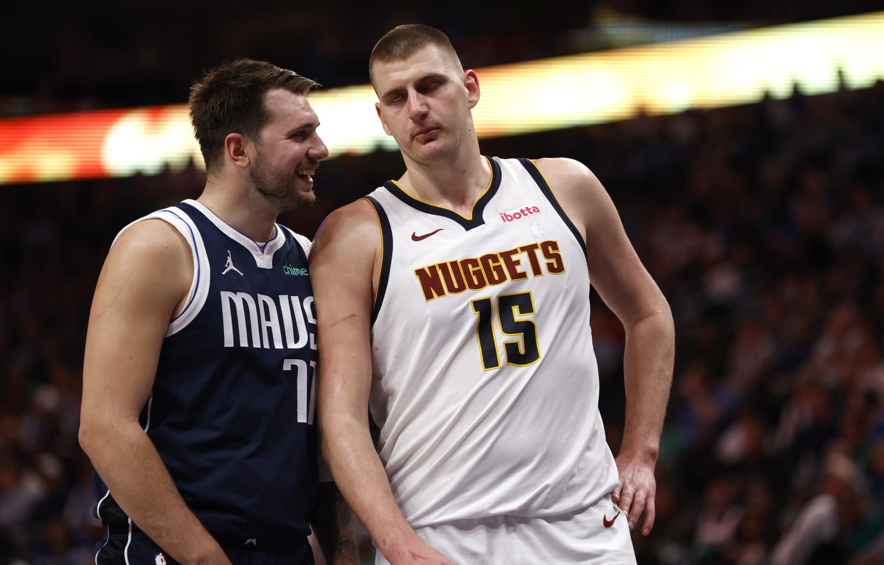 DALLAS, TX - MARCH 17: Luka Doncic #77 of the Dallas Mavericks and Nikola Jokic #15 of the Denver Nuggets talk during a beak in the action in the second half at American Airlines Center on March 17, 2024 in Dallas, Texas. NOTE TO USER: User expressly acknowledges and agrees that, by downloading and or using this photograph, User is consenting to the terms and conditions of the Getty Images License Agreement. (Photo by Ron Jenkins/Getty Images)