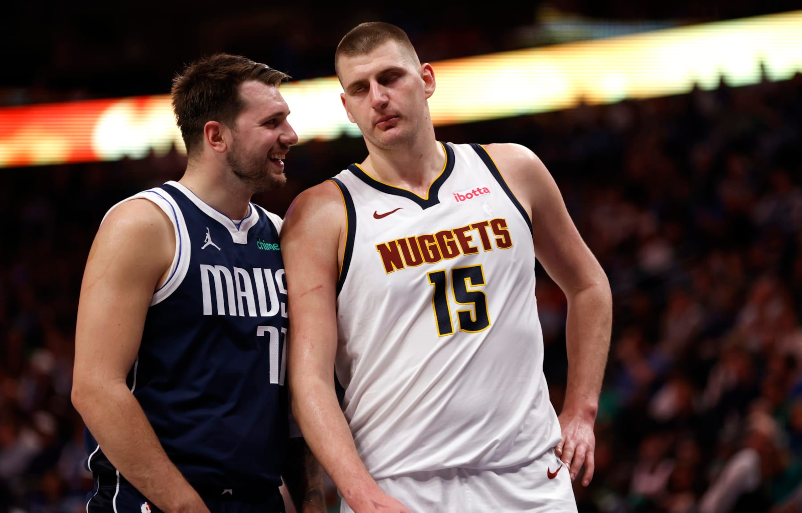 DALLAS, TX - MARCH 17: Luka Doncic #77 of the Dallas Mavericks and Nikola Jokic #15 of the Denver Nuggets talk during a beak in the action in the second half at American Airlines Center on March 17, 2024 in Dallas, Texas. NOTE TO USER: User expressly acknowledges and agrees that, by downloading and or using this photograph, User is consenting to the terms and conditions of the Getty Images License Agreement. (Photo by Ron Jenkins/Getty Images)