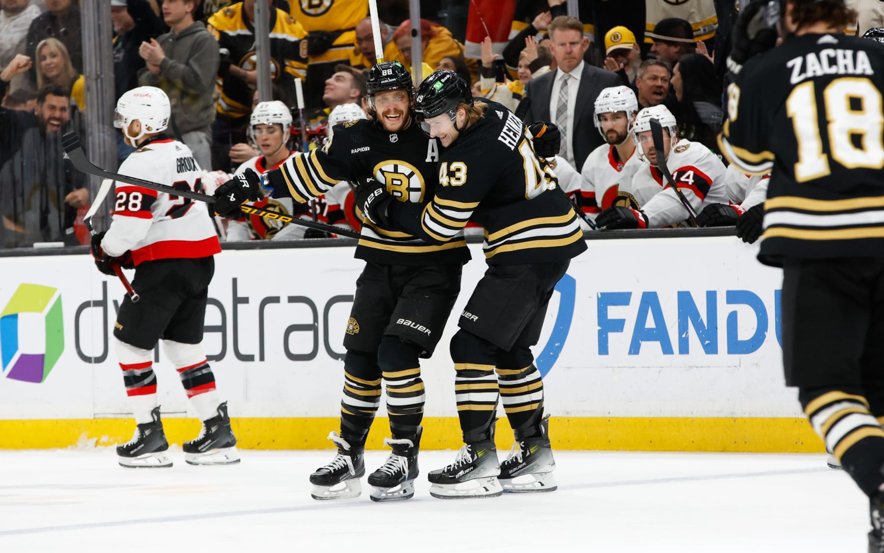 BOSTON, MASSACHUSETTS - MARCH 19: David Pastrnak #88 of the Boston Bruins celebrates his hat trick against the Ottawa Senators with teammate Danton Heinen #43 during the third period at the TD Garden on March 19, 2024 in Boston, Massachusetts. (Photo by Rich Gagnon/Getty Images)