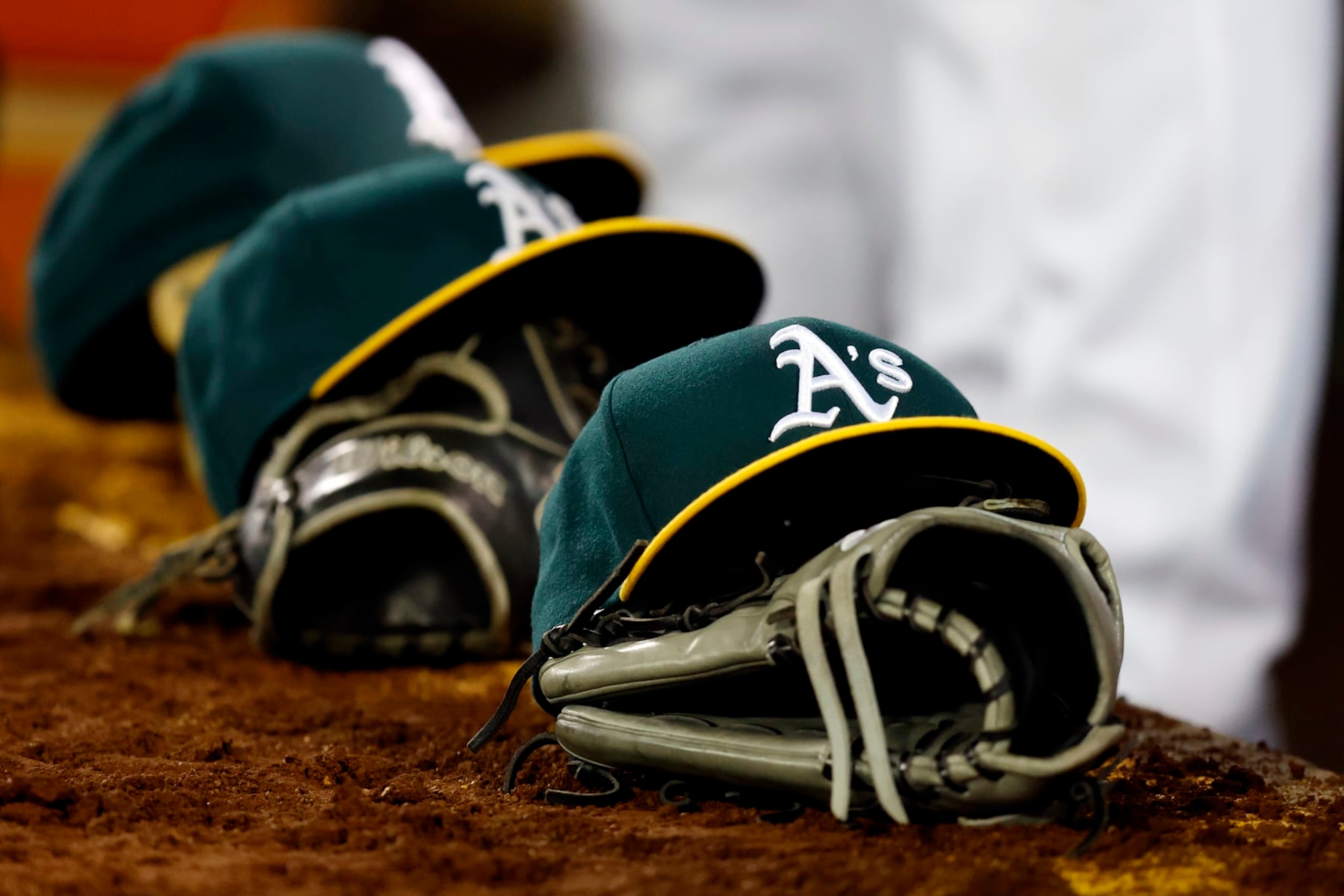 OAKLAND, CA - MARCH 28:  A detail shot of Oakland Athletics hats and gloves on the dugout steps during the game between the Cleveland Guardians and the Oakland Athletics at RingCentral Coliseum on Thursday, March 28, 2024 in Oakland, California. (Photo by Lachlan Cunningham/MLB Photos via Getty Images)