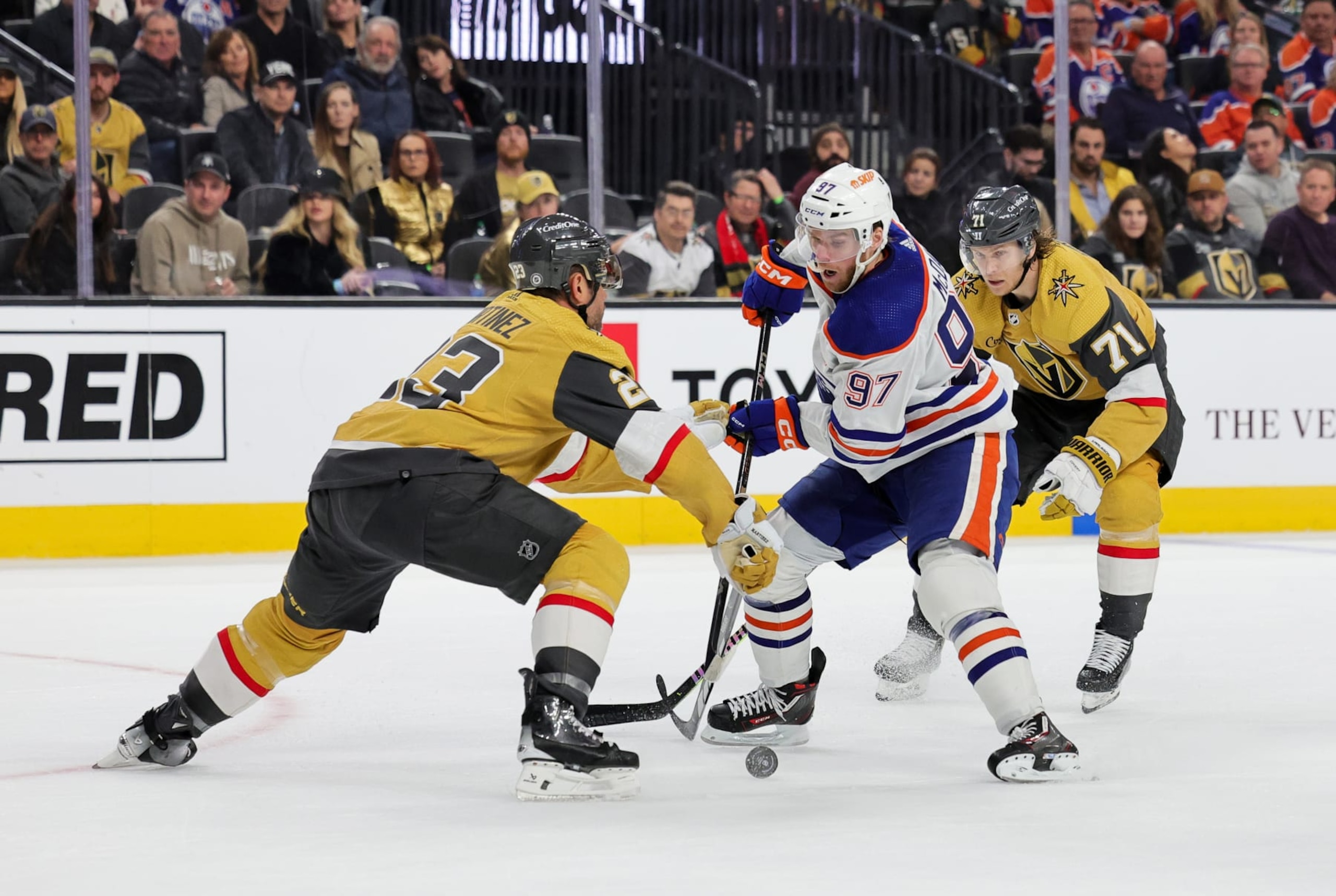 LAS VEGAS, NEVADA - FEBRUARY 06: Connor McDavid #97 of the Edmonton Oilers skates with the puck against Alec Martinez #23 and William Karlsson #71 of the Vegas Golden Knights in the third period of their game at T-Mobile Arena on February 06, 2024 in Las Vegas, Nevada. The Golden Knights defeated the Oilers 3-1. (Photo by Ethan Miller/Getty Images)