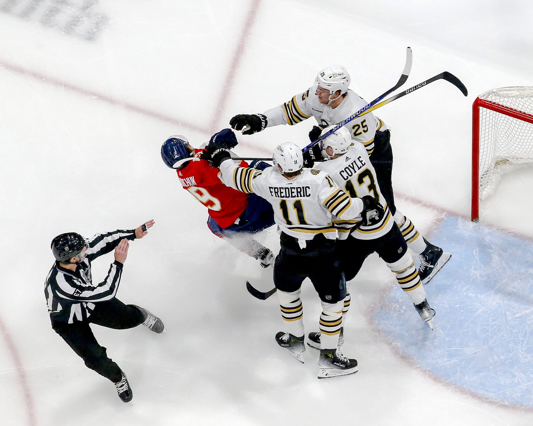 SUNRISE, FL - MARCH 26: Trent Frederic #11, Charlie Coyle #13, and Brandon Carlo #25 of the Boston Bruins go after Matthew Tkachuk #19 of the Florida Panthers at the side of the net at the Amerant Bank Arena on March 26, 2024 in Sunrise, Florida. (Photo by Joel Auerbach/Getty Images)