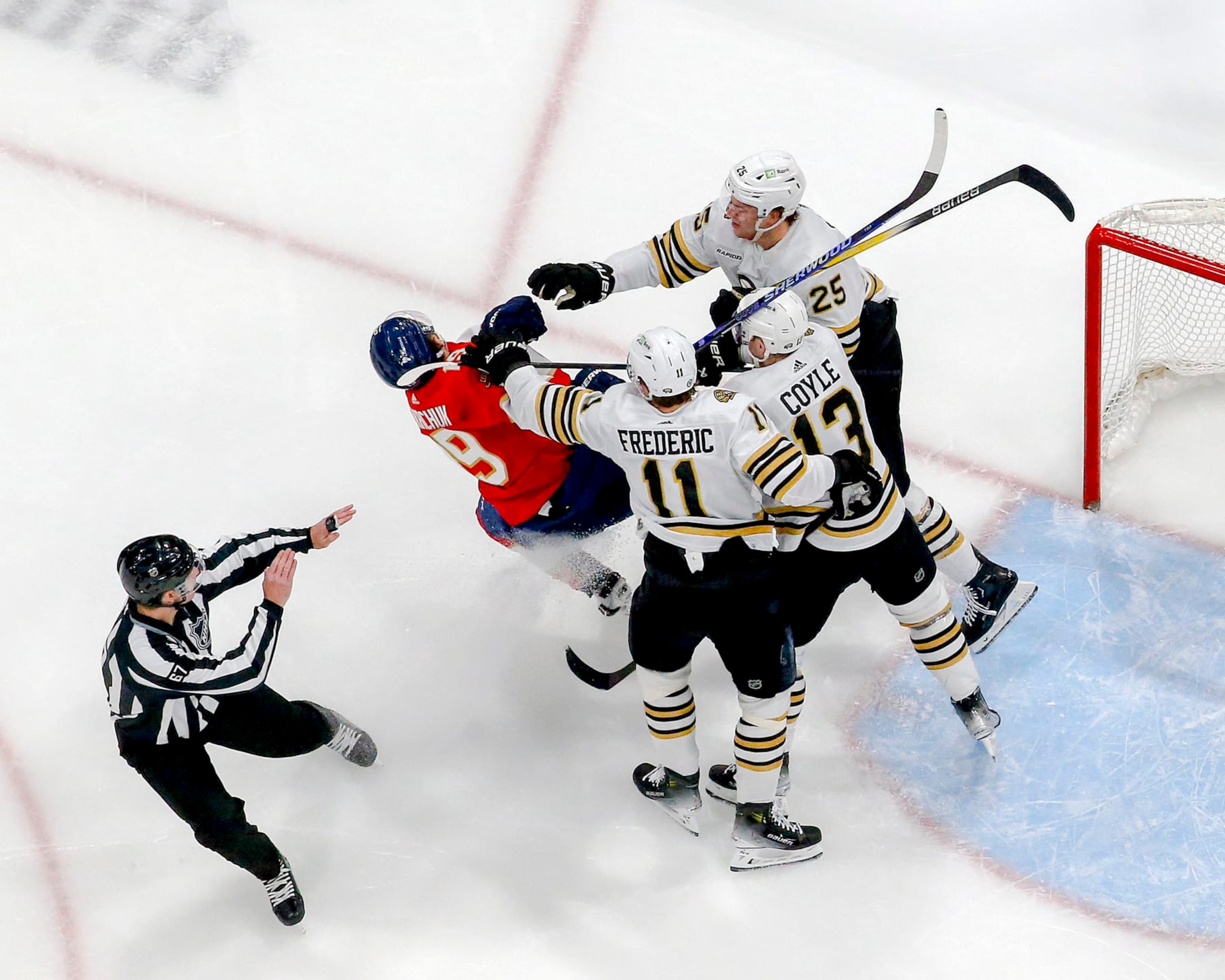 SUNRISE, FL - MARCH 26: Trent Frederic #11, Charlie Coyle #13, and Brandon Carlo #25 of the Boston Bruins go after Matthew Tkachuk #19 of the Florida Panthers at the side of the net at the Amerant Bank Arena on March 26, 2024 in Sunrise, Florida. (Photo by Joel Auerbach/Getty Images)