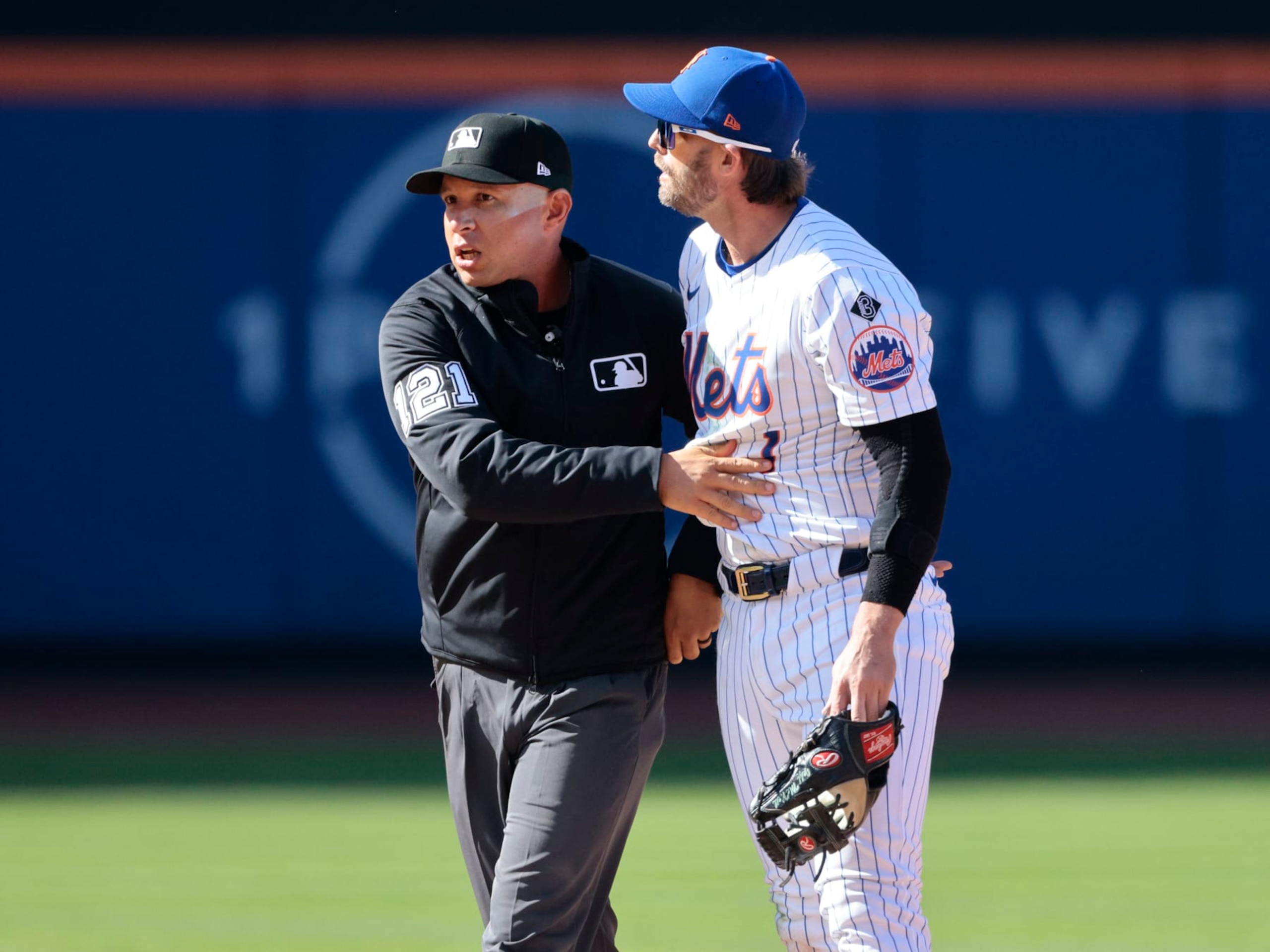 NEW YORK, NEW YORK - MARCH 29: Jeff McNeil #1 of the New York Mets is held back by umpire Jonathan Parra #121 after a play involving Rhys Hoskins #12 of the Milwaukee Brewers during the top of the eighth inning in the home opener at Citi Field on March 29, 2024 in New York City. (Photo by Christopher Pasatieri/Getty Images)