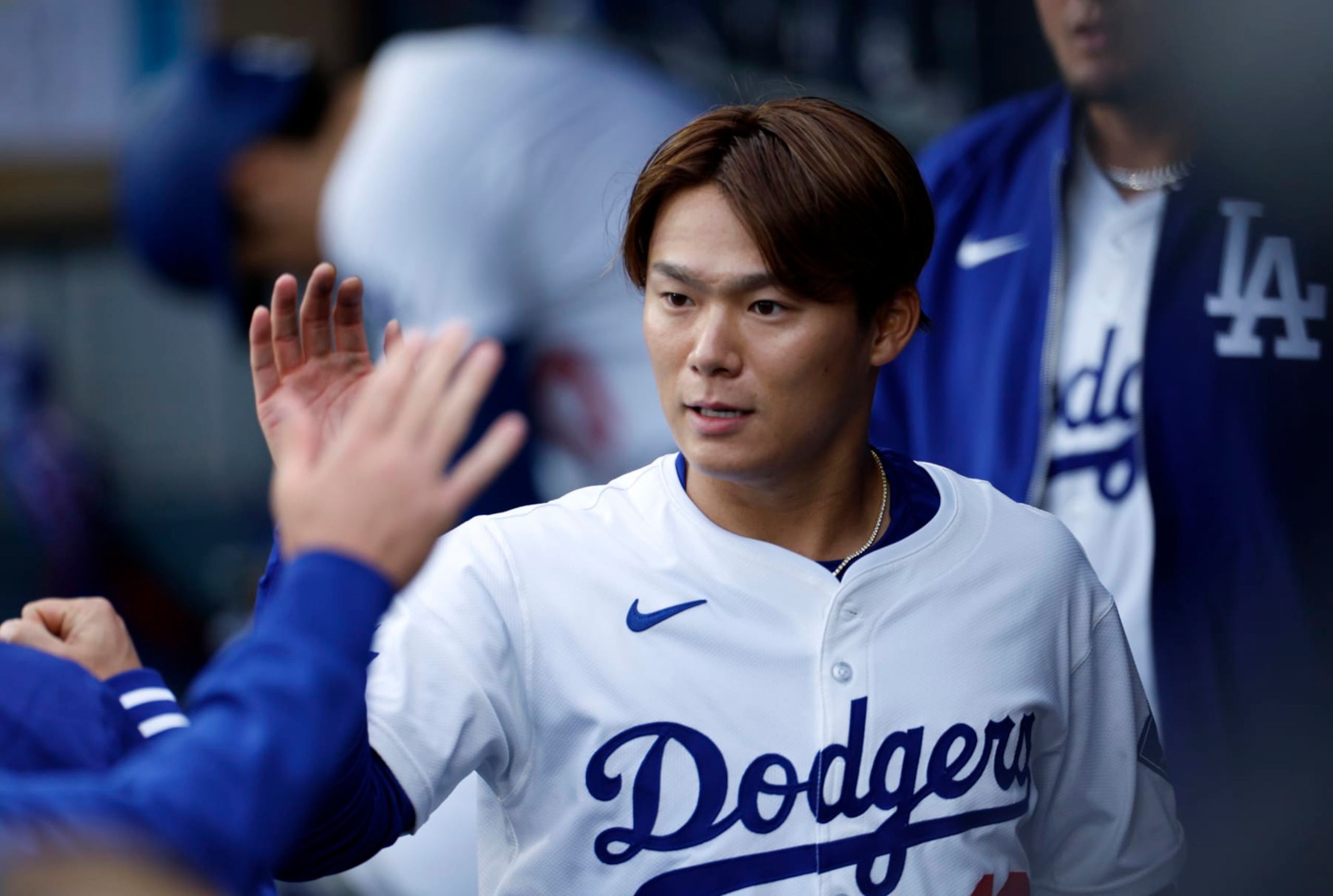 LOS ANGELES, CALIFORNIA - MARCH 30: Pitcher Yoshinobu Yamamoto #18 of the Los Angeles Dodgers is congratulated in the dugout after the last out the first inning making his Dodger Stadium debut against the the St. Louis Cardinals on March 30, 2024 in Los Angeles, California. (Photo by Kevork Djansezian/Getty Images)